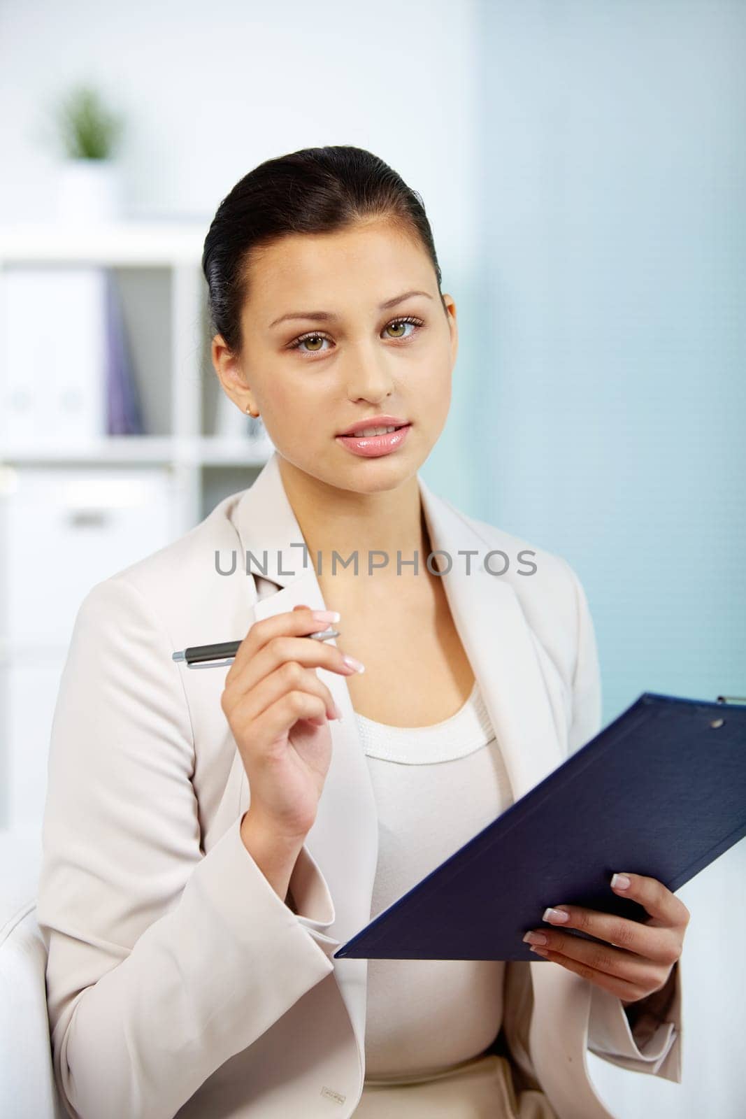Portrait of smiling businesswoman with pen and clipboard looking at camera