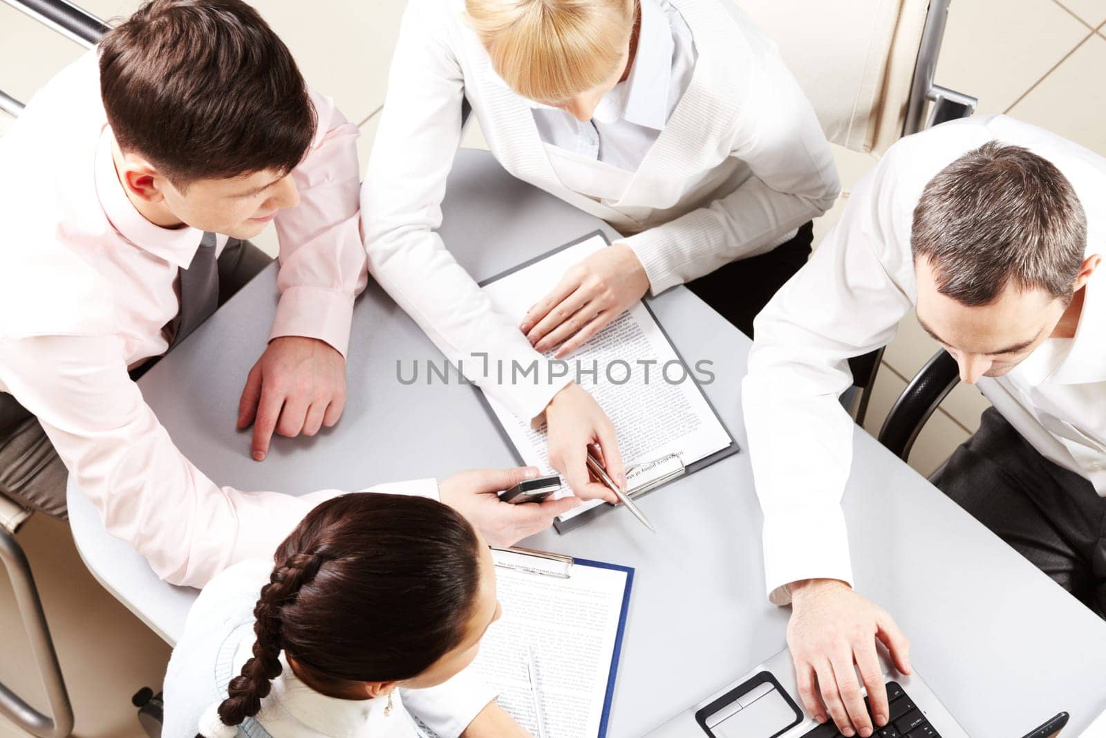Above view of friendly workteam discussing business papers