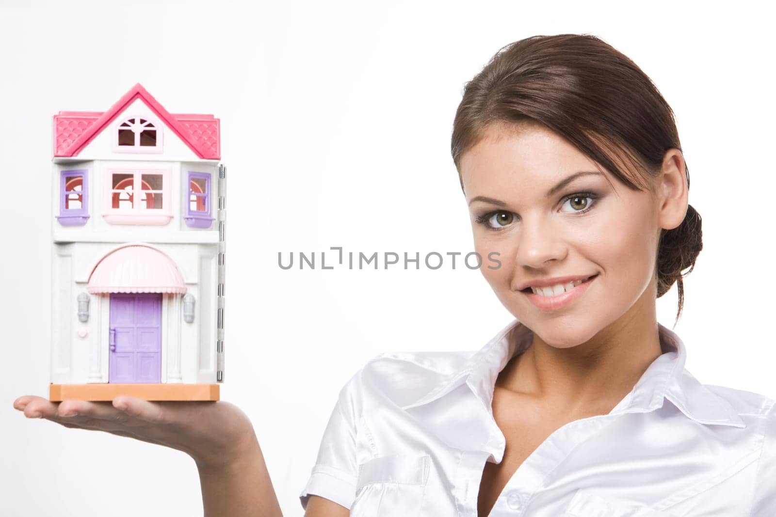 Image of pretty woman holding toy house on her palm