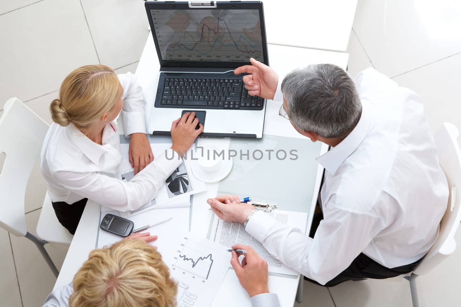 Above view of workteam discussing computer project at meeting