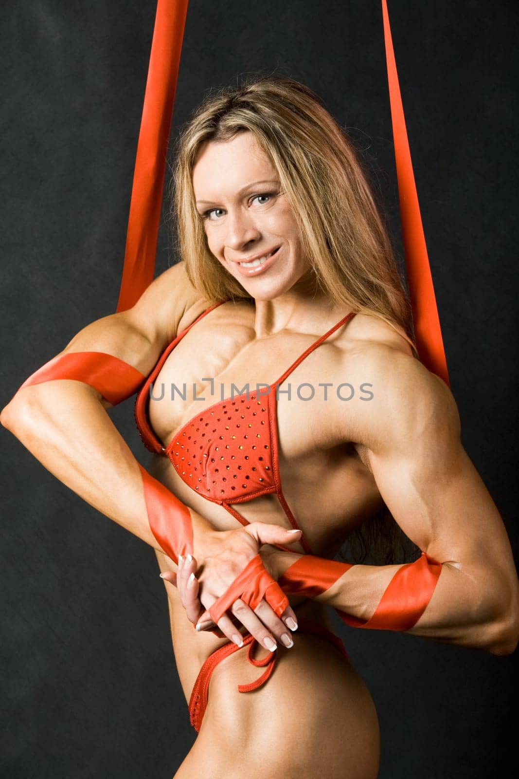 Portrait of strong female in red bikini smiling and looking at camera