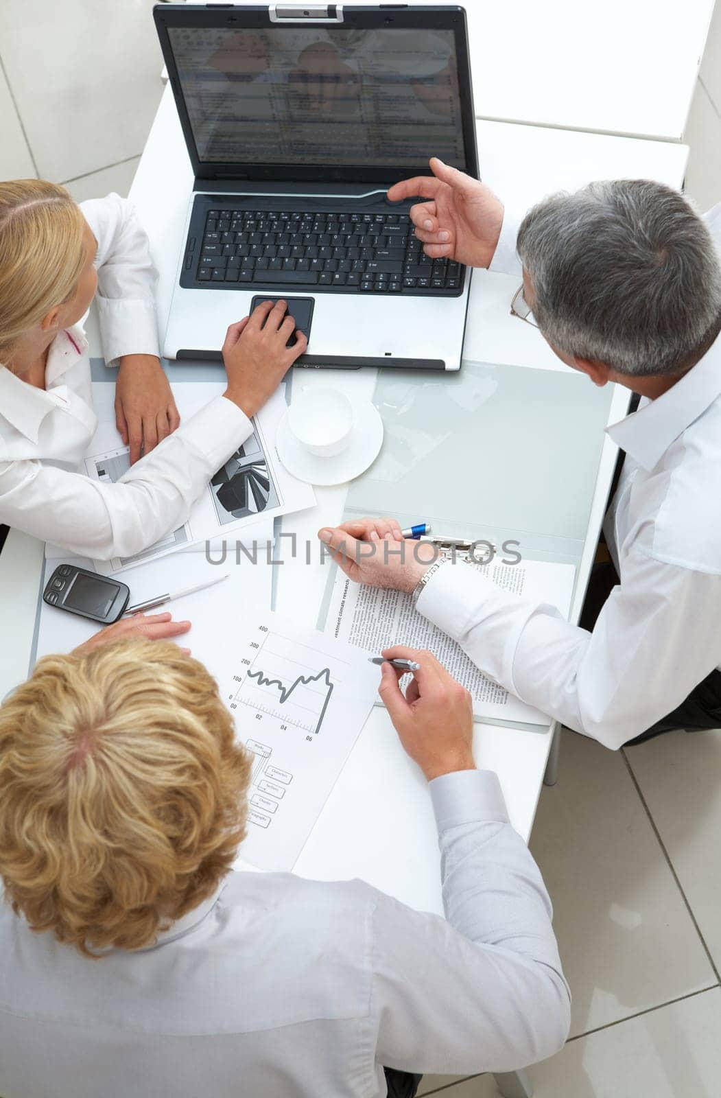 Above view of workteam discussing computer project at meeting
