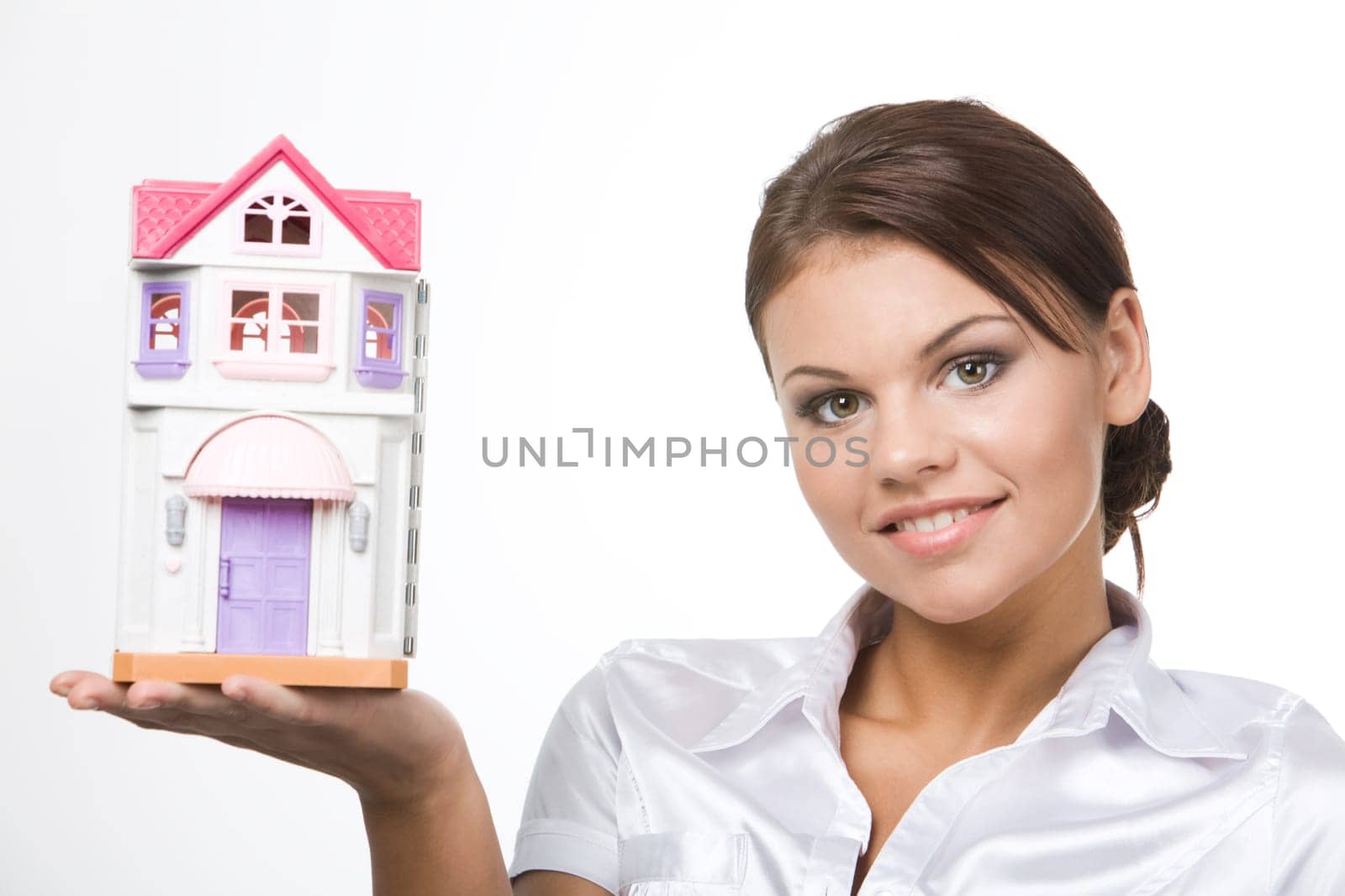 Portrait of young woman holding toy house on a white background