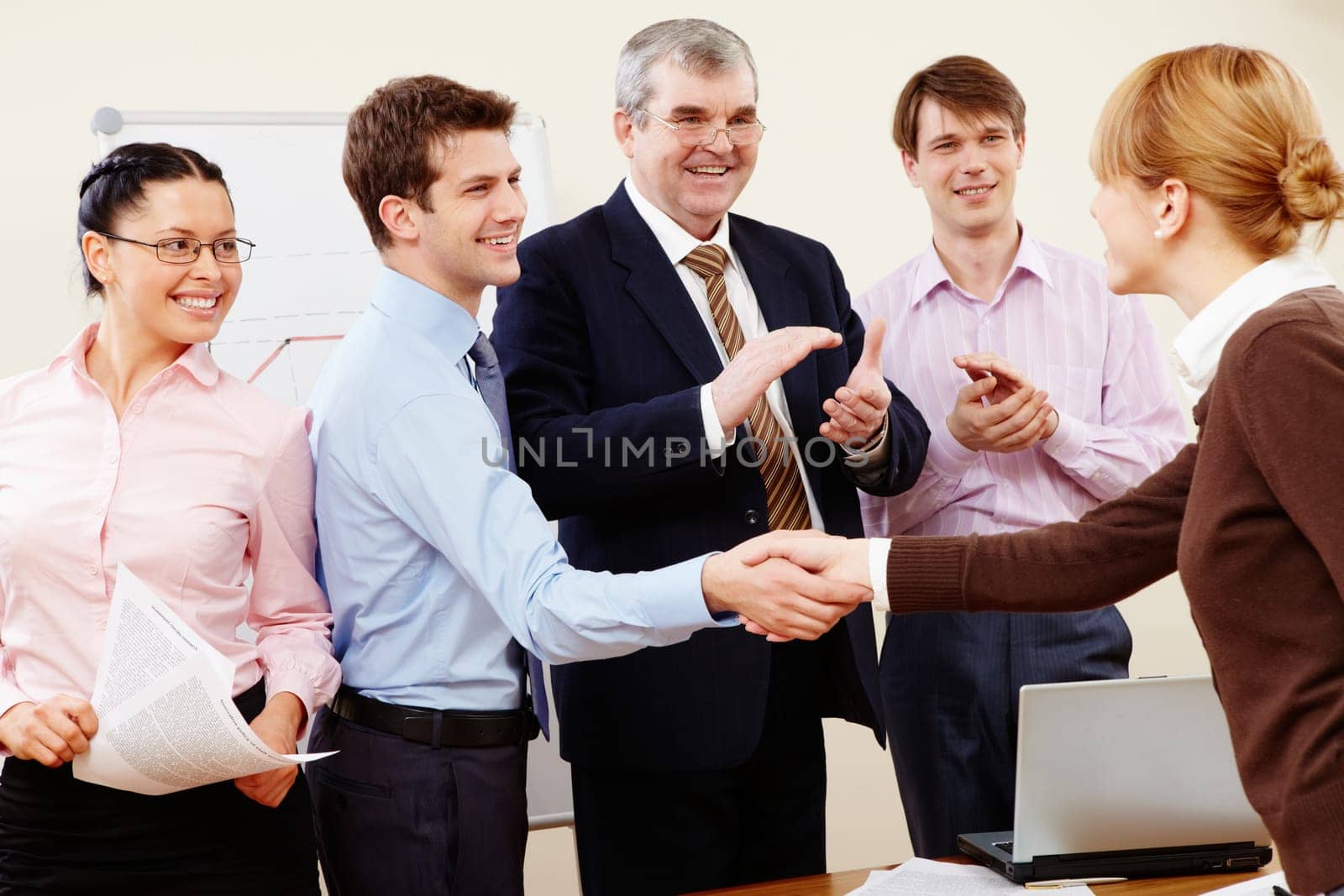 Photo of successful business partners handshaking after striking great deal with applauding people near by