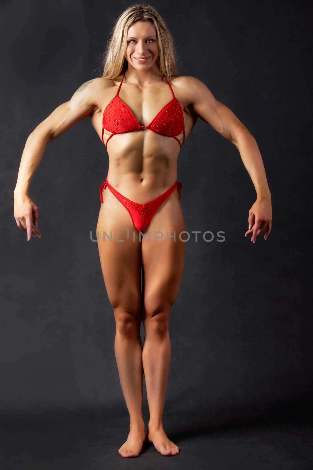 A beautiful woman bodybuilder posing in red bikini