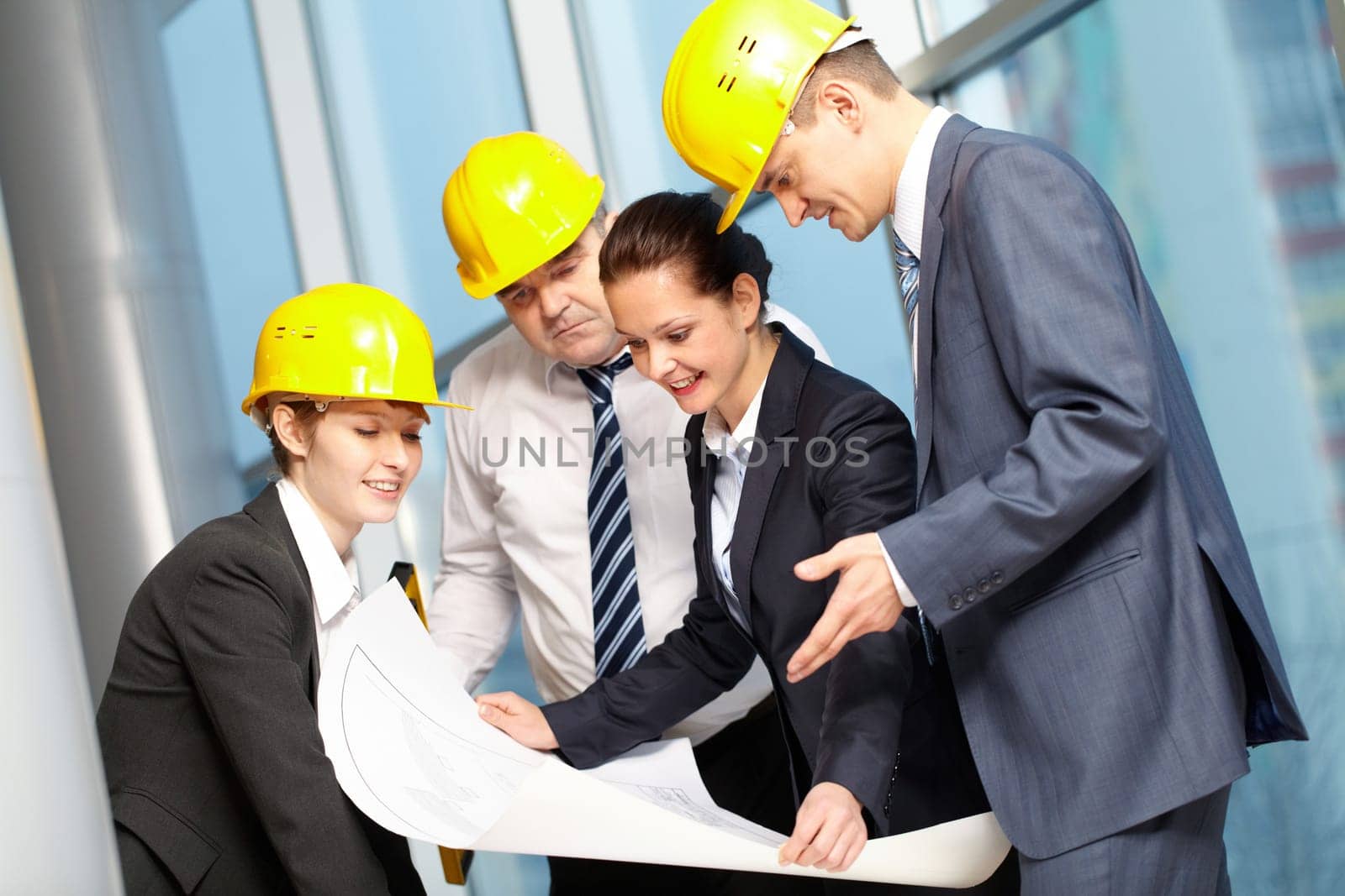 Four confident engineers discussing a plan