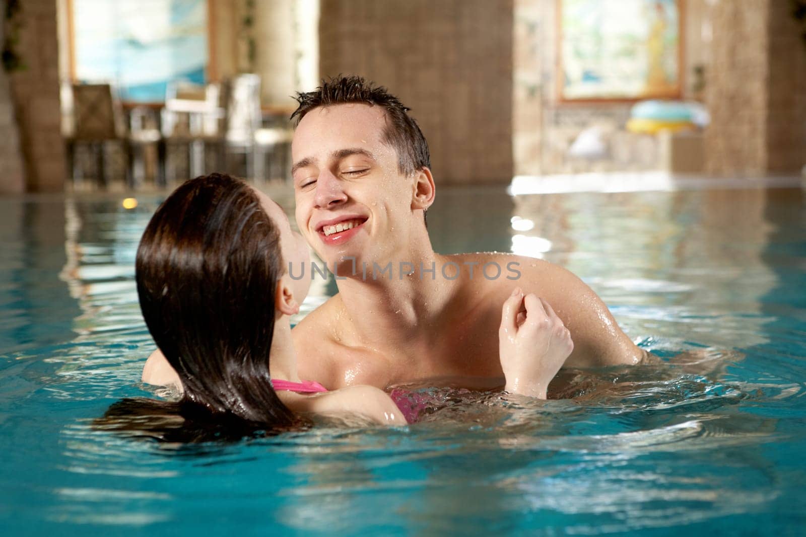 Photo of happy man and pretty girl interacting in swimming pool