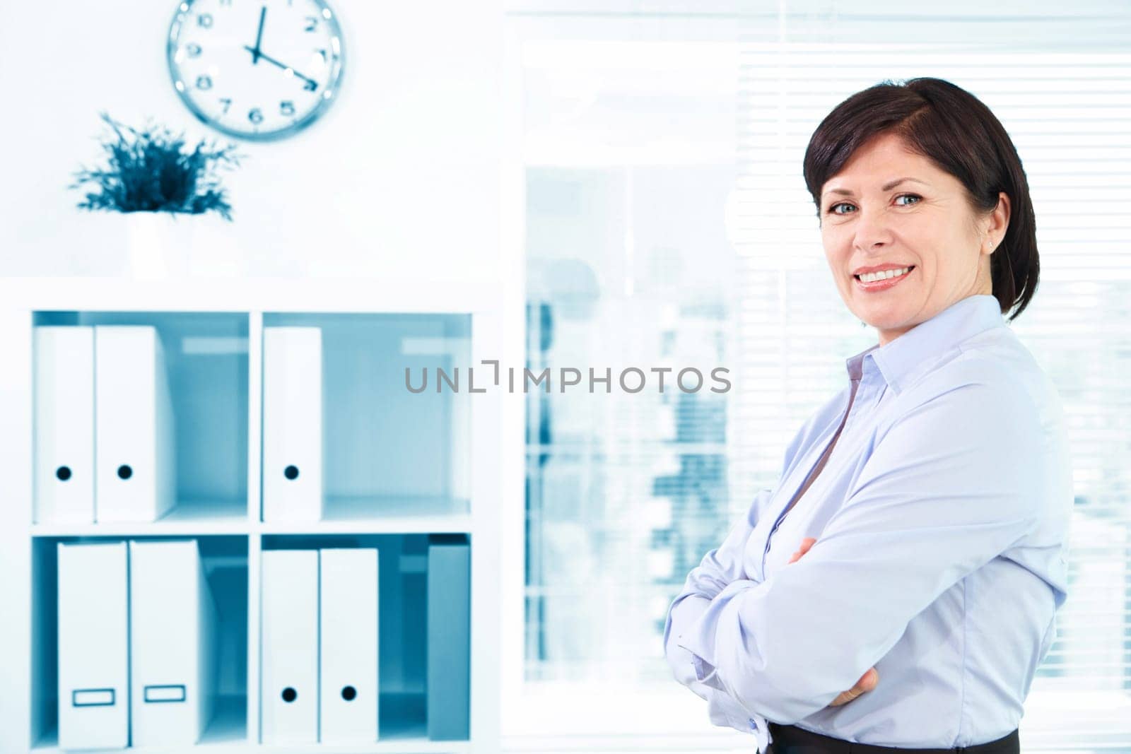 Mature businesswoman looking at camera in office