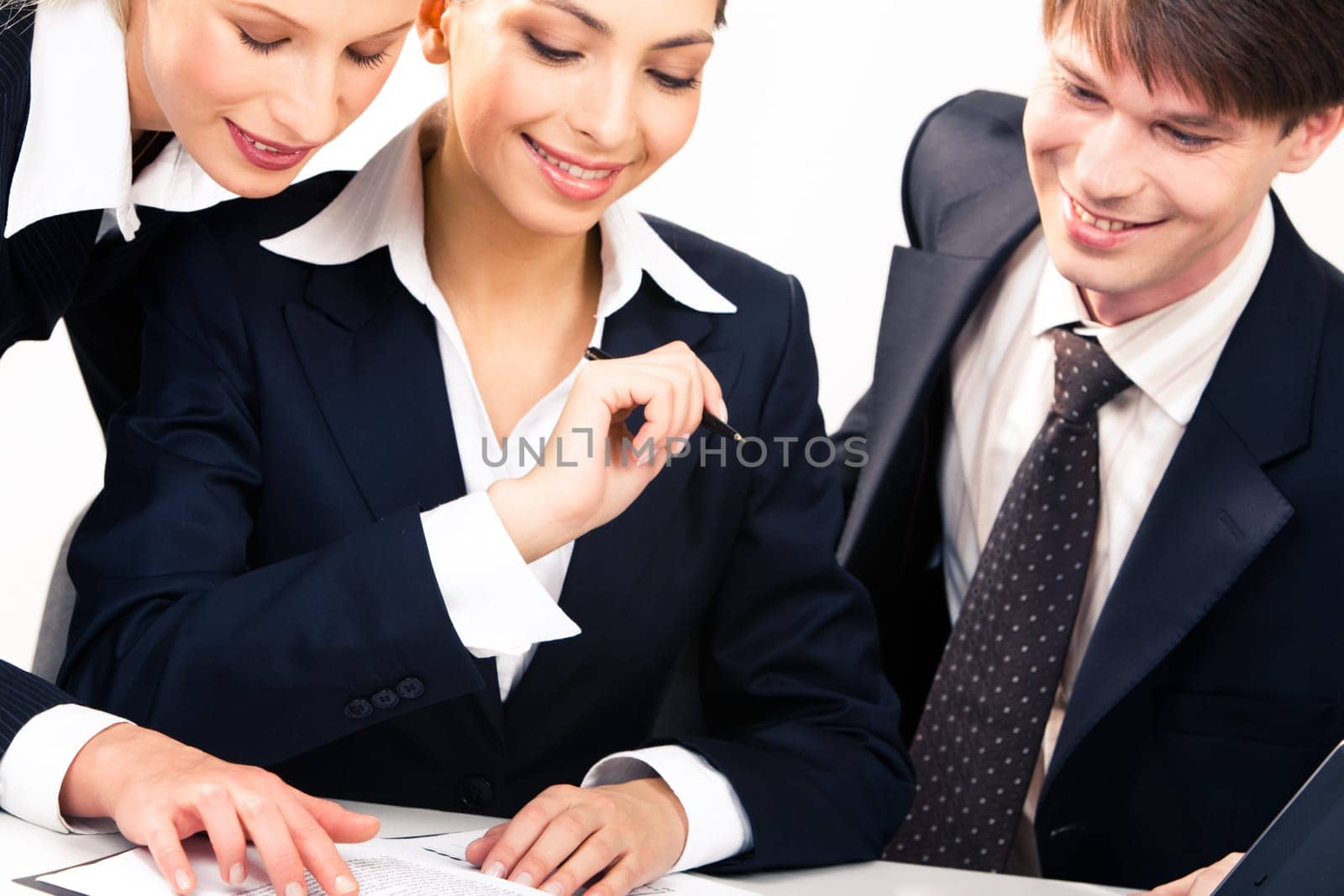 Portrait of business partners sitting around table and looking at document with smiles