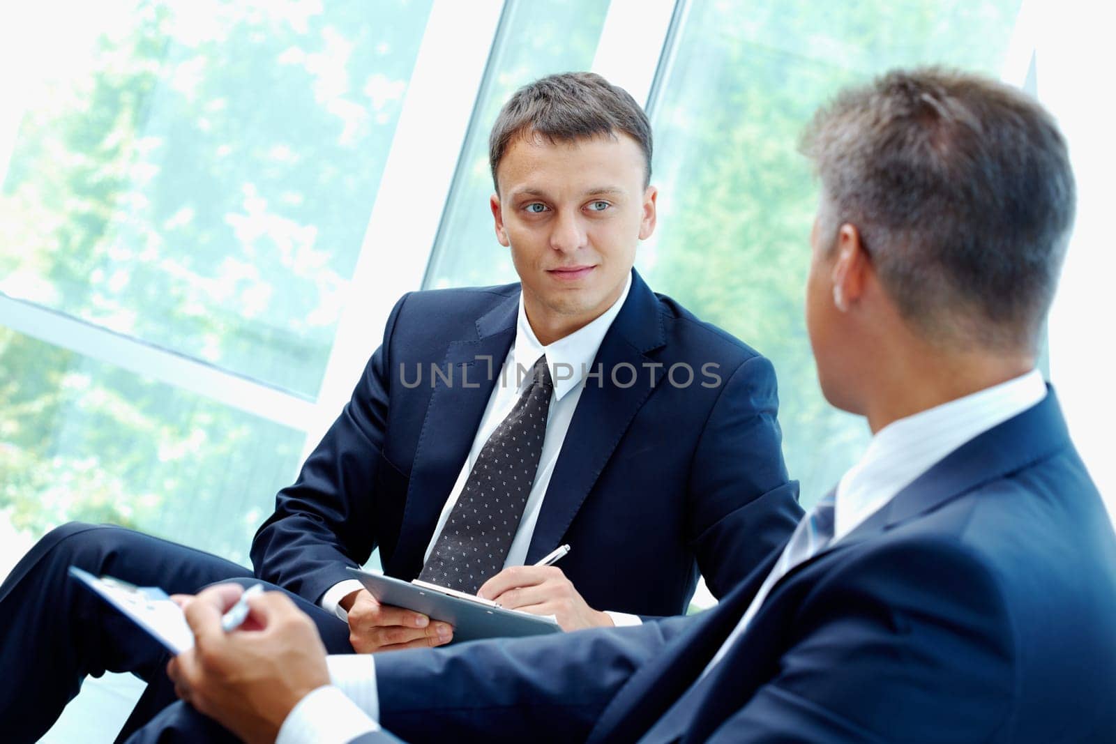 Image of smart businessman explaining new strategy to his partner at meeting