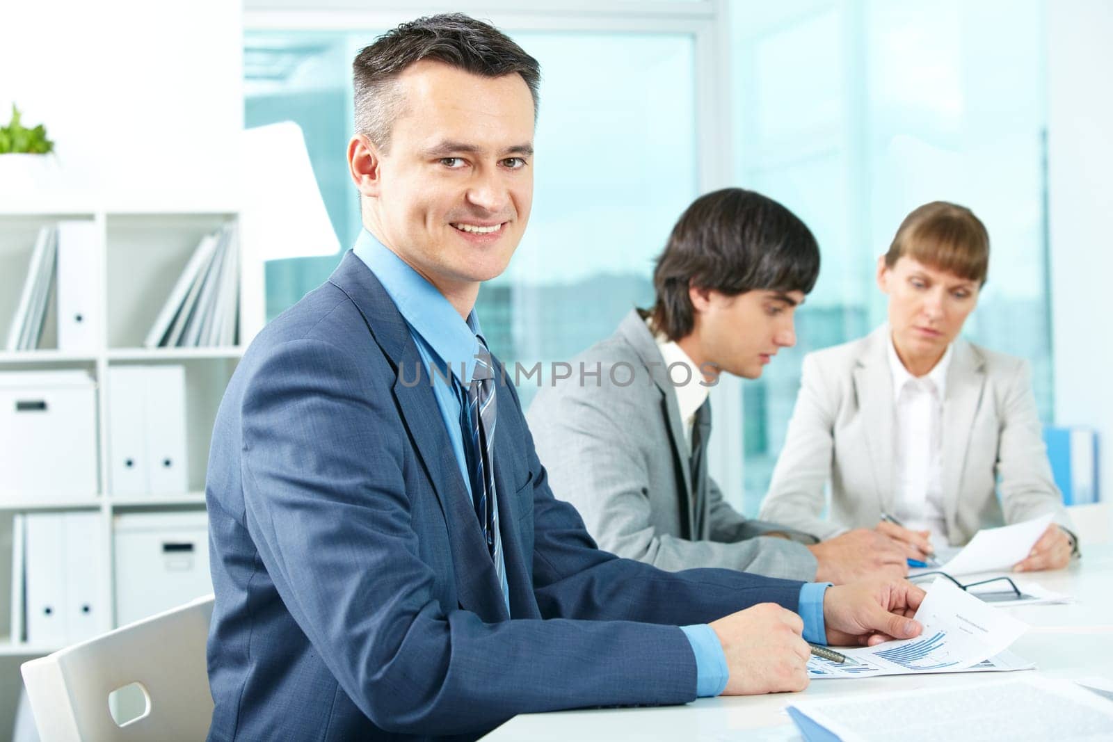 Successful businessman looking at camera in working environment