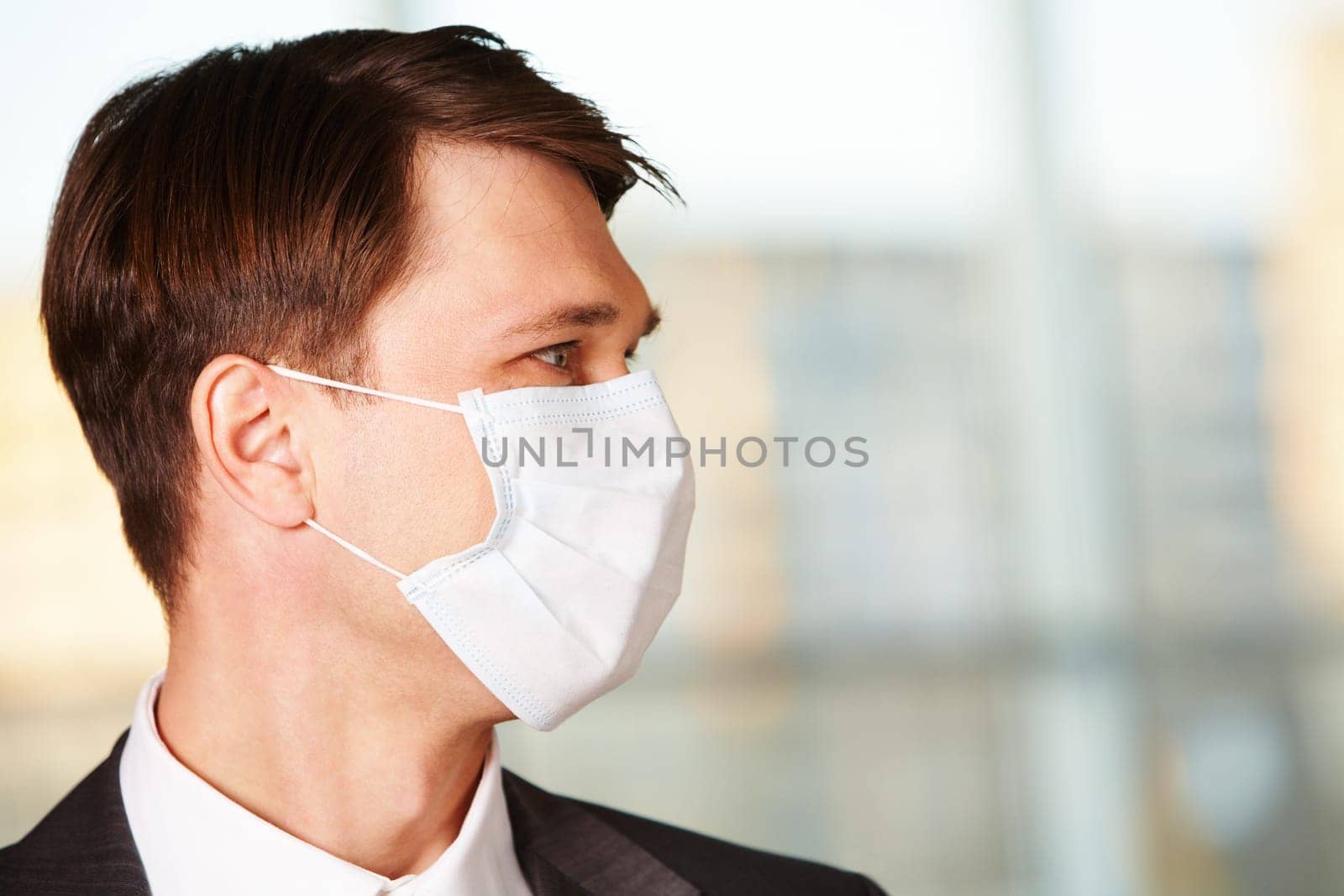 Portrait of businessman in protective mask looking forwards