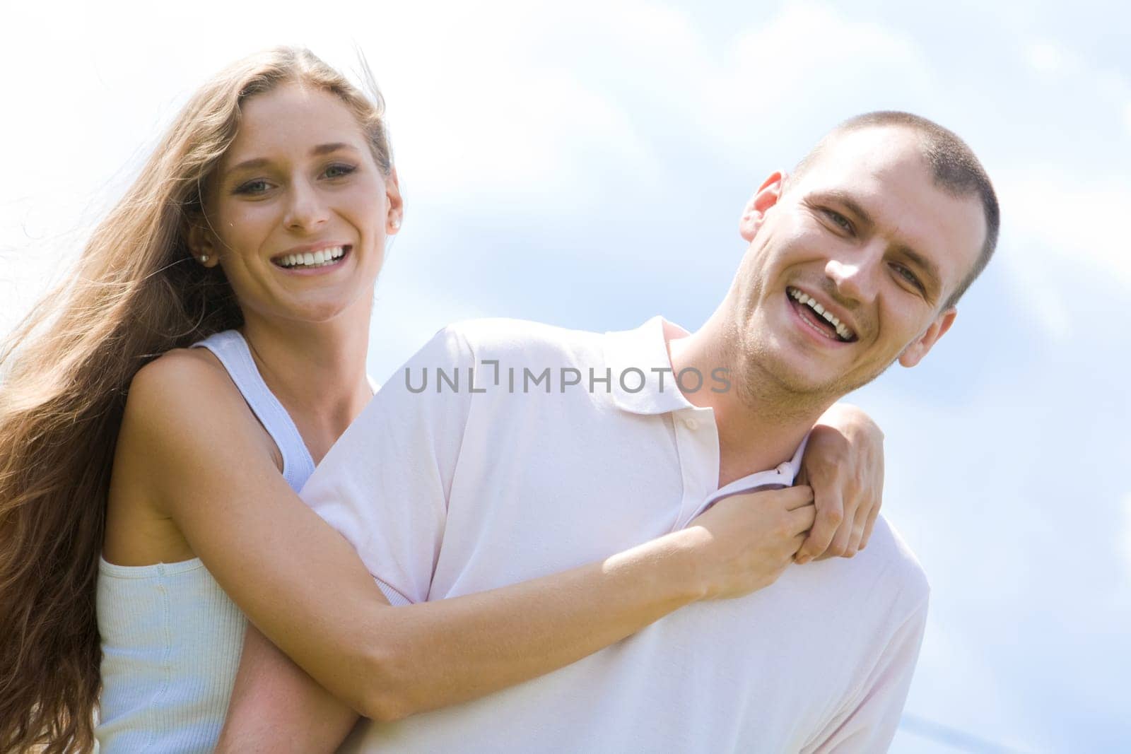 Portrait of happy girl hugging handsome man outside