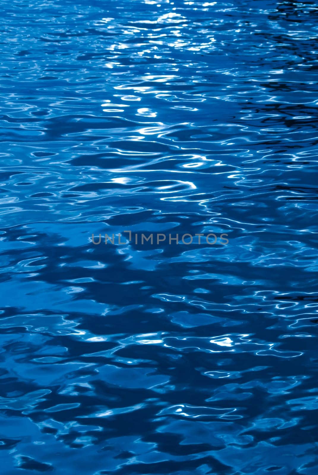 blue water texture with some reflections of the sun