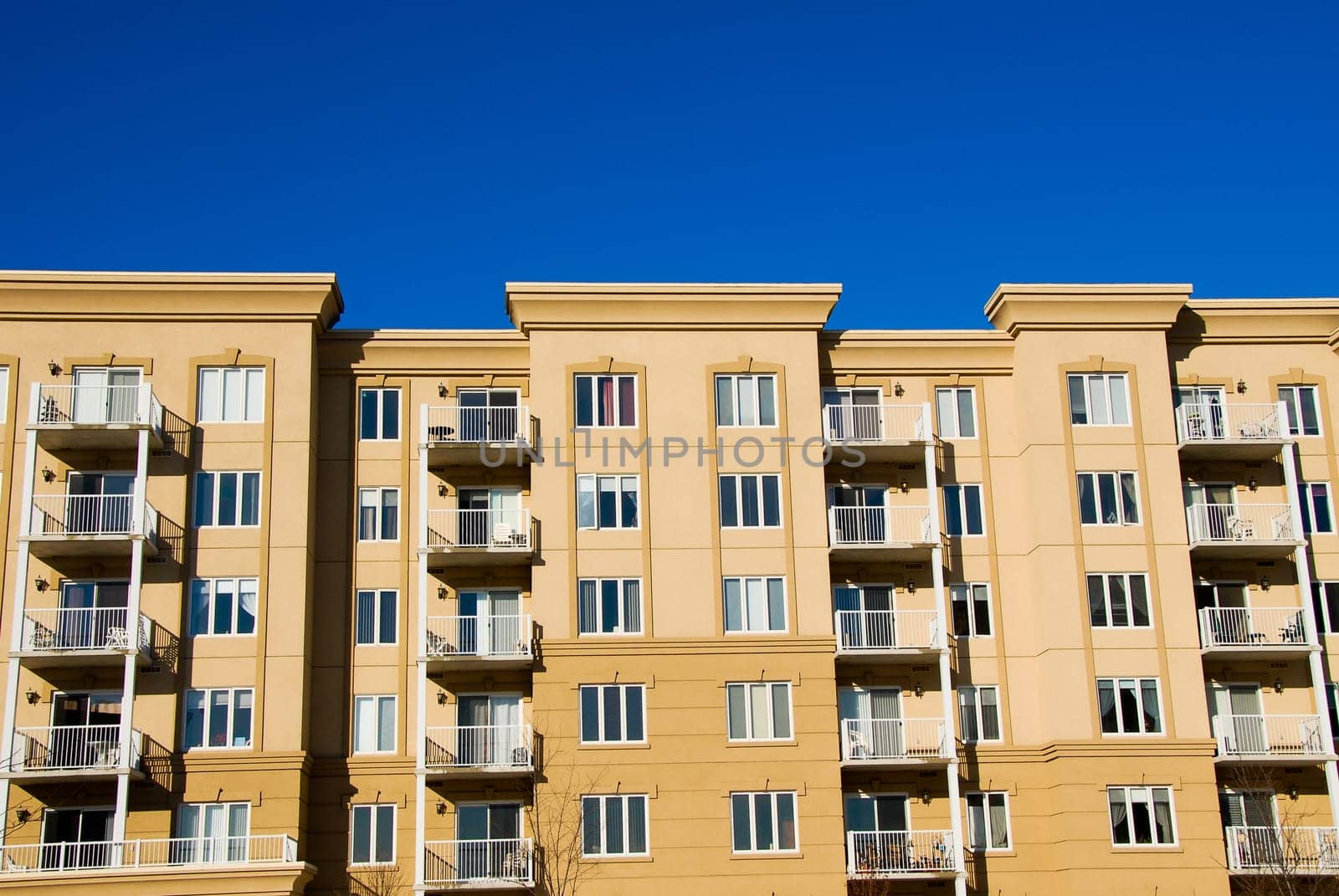 modern beige and brown apartment condos on blue sky