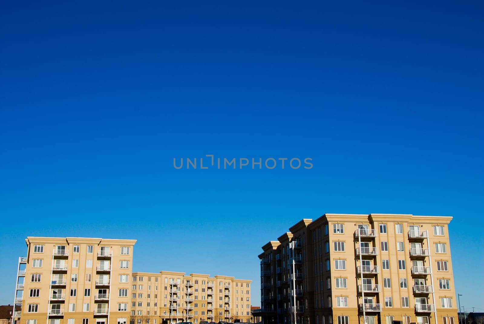 modern beige and brown apartment condos on blue sky