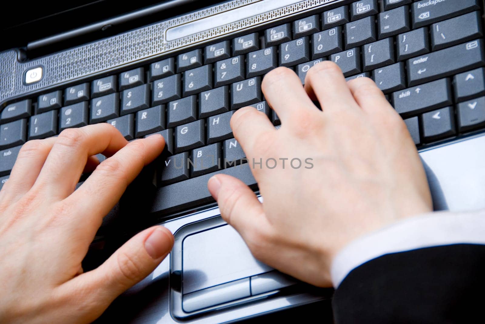 woman in a meeting typing on her laptop