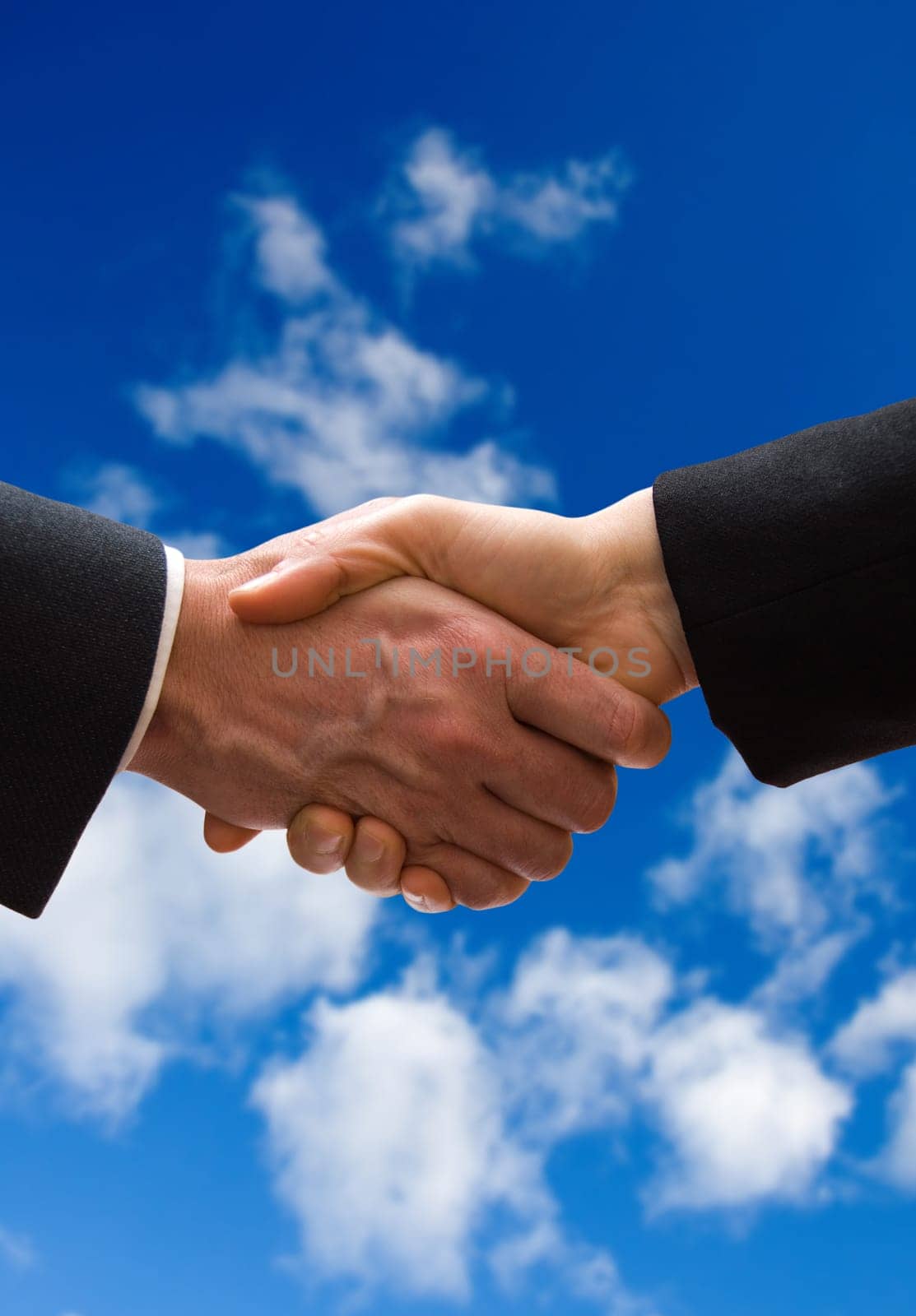A business hand shake on a summer clouds background