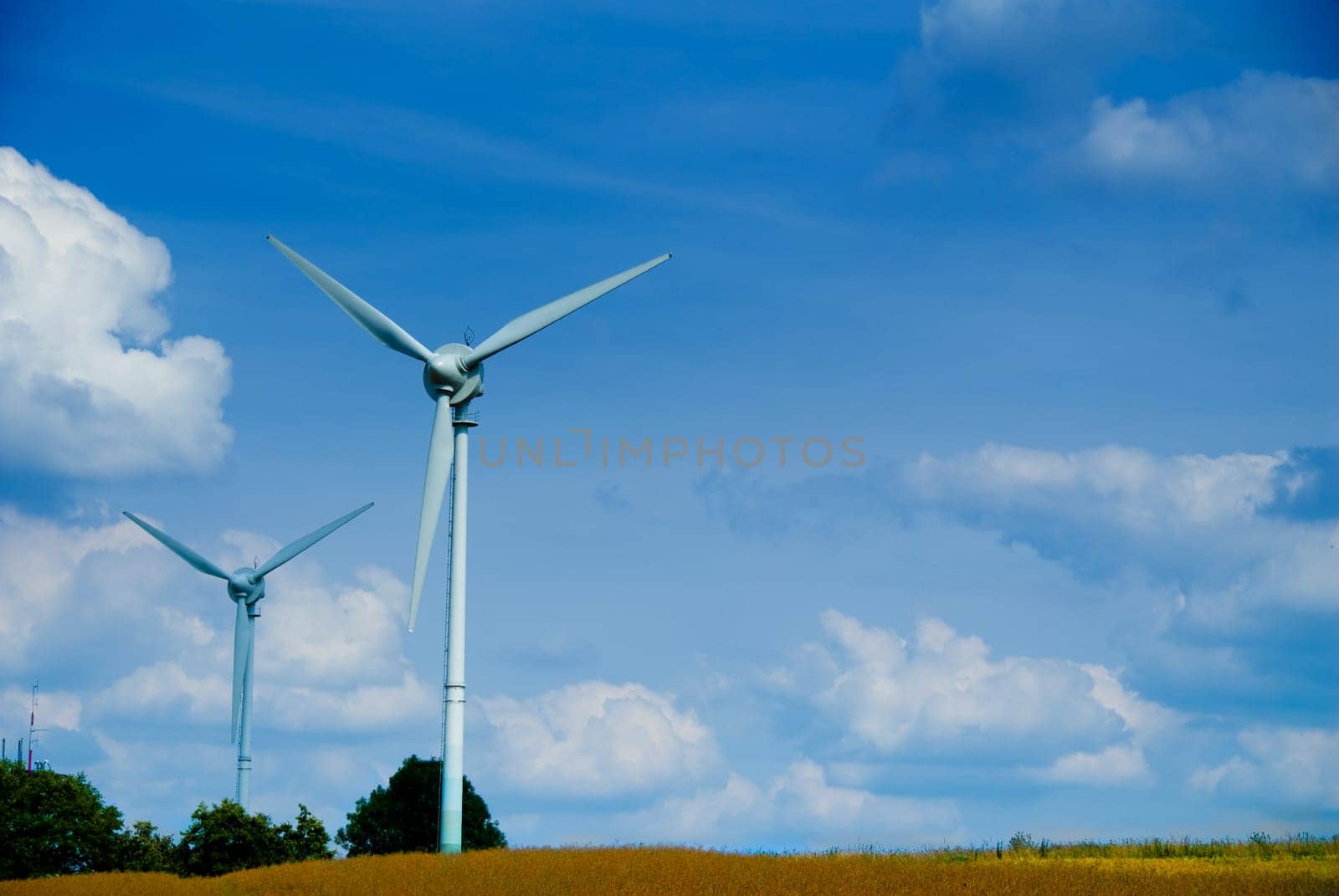 clean energy white wind turbine in wheat field