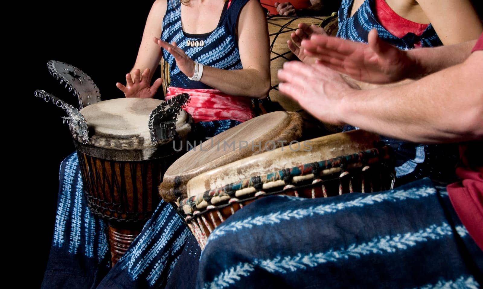 three musicians playing drums in a studio