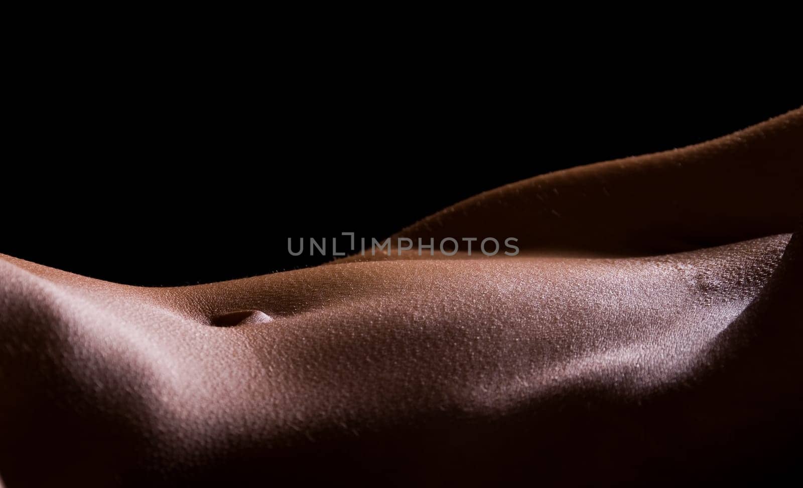 Female Tummy in the nude on black background