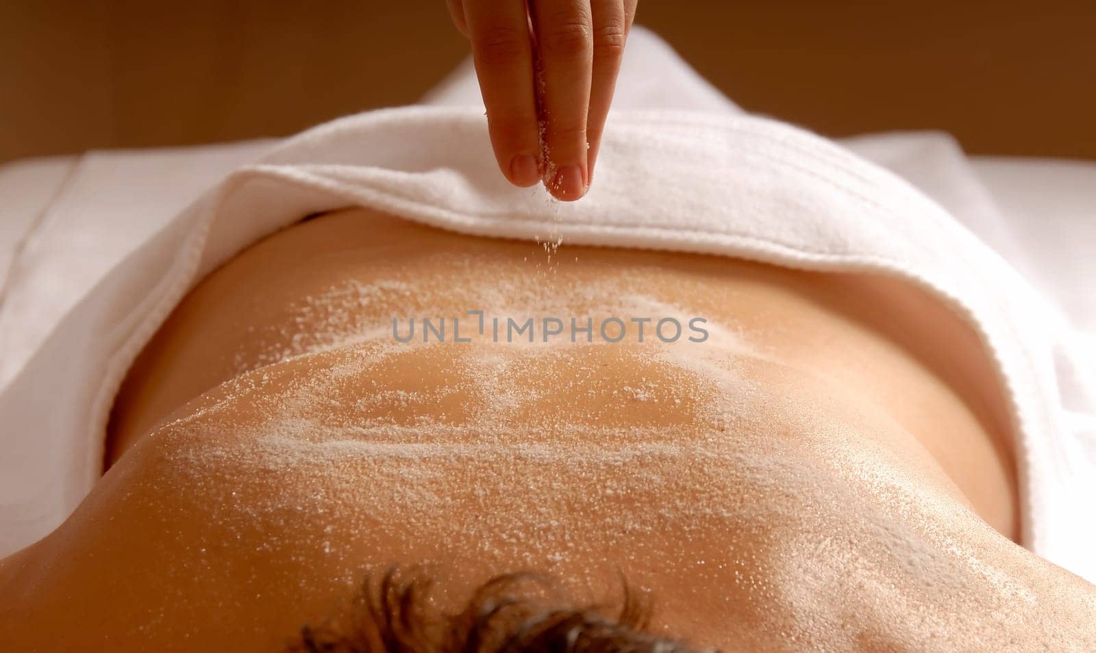 therapist dropping epsom salt on client body