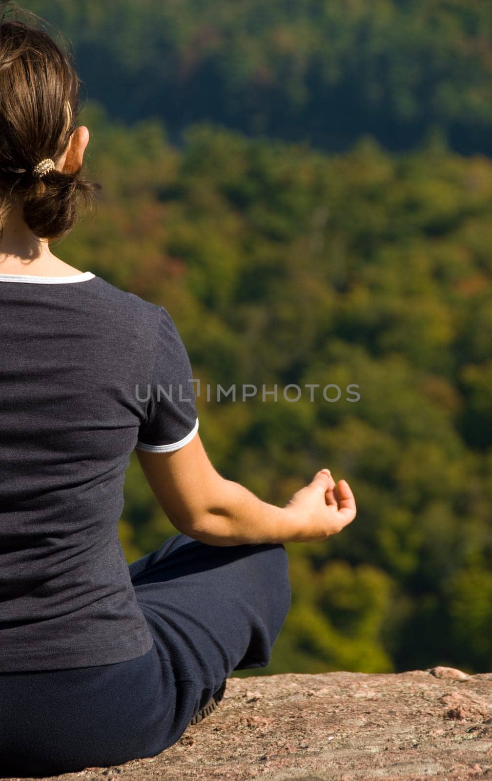 Woman on the top of a mountain meditating