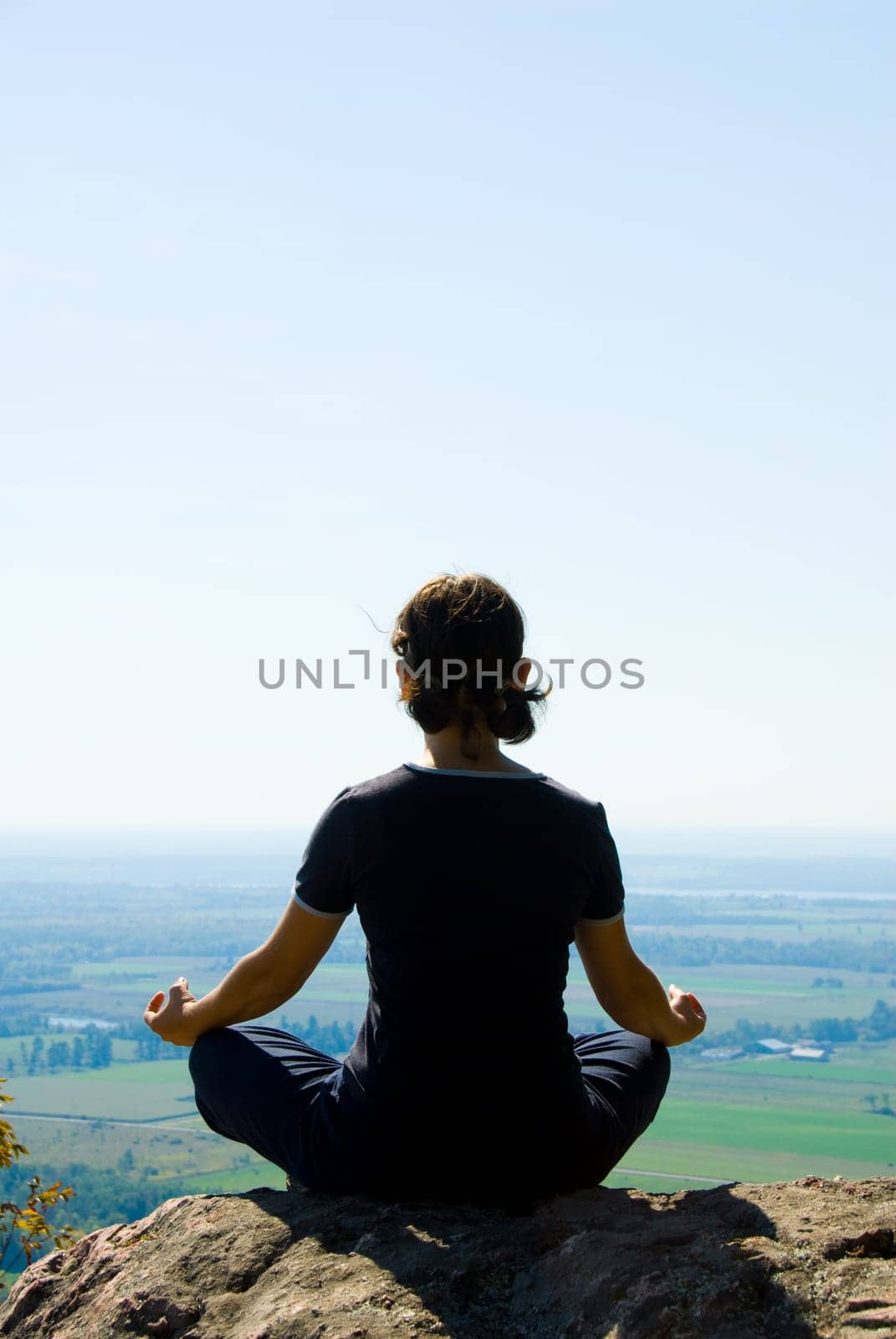 Woman on the top of a mountain meditating