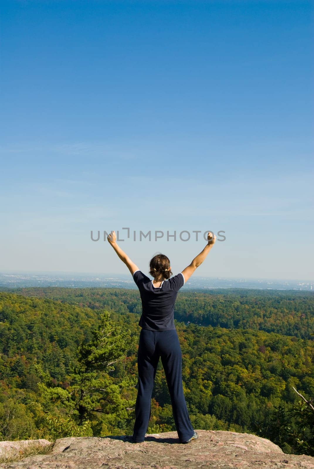 Woman on the top of a mountain happy