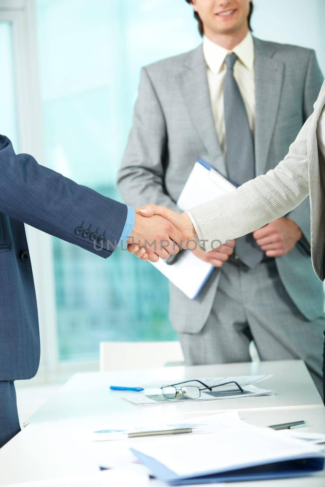 Photo of handshake of business partners after striking deal on background of elegant man
