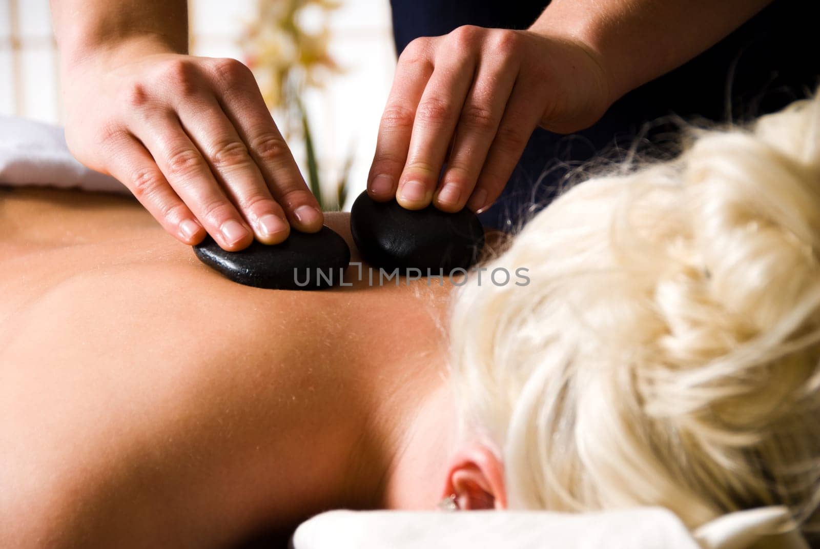 woman getting a hot stone massage at a day spa