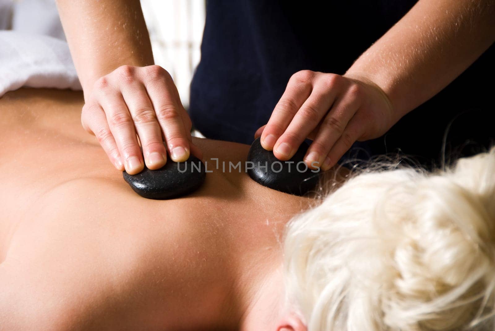 woman getting a hot stone massage at a day spa