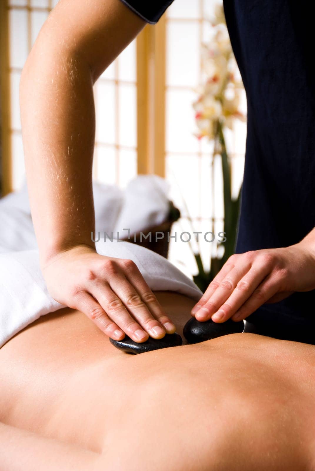 woman getting a hot stone massage at a day spa