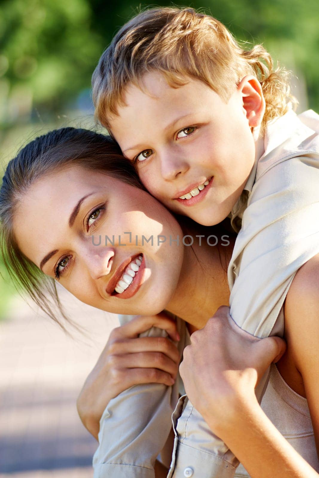 Happy mother holding her cute son and both looking at camera