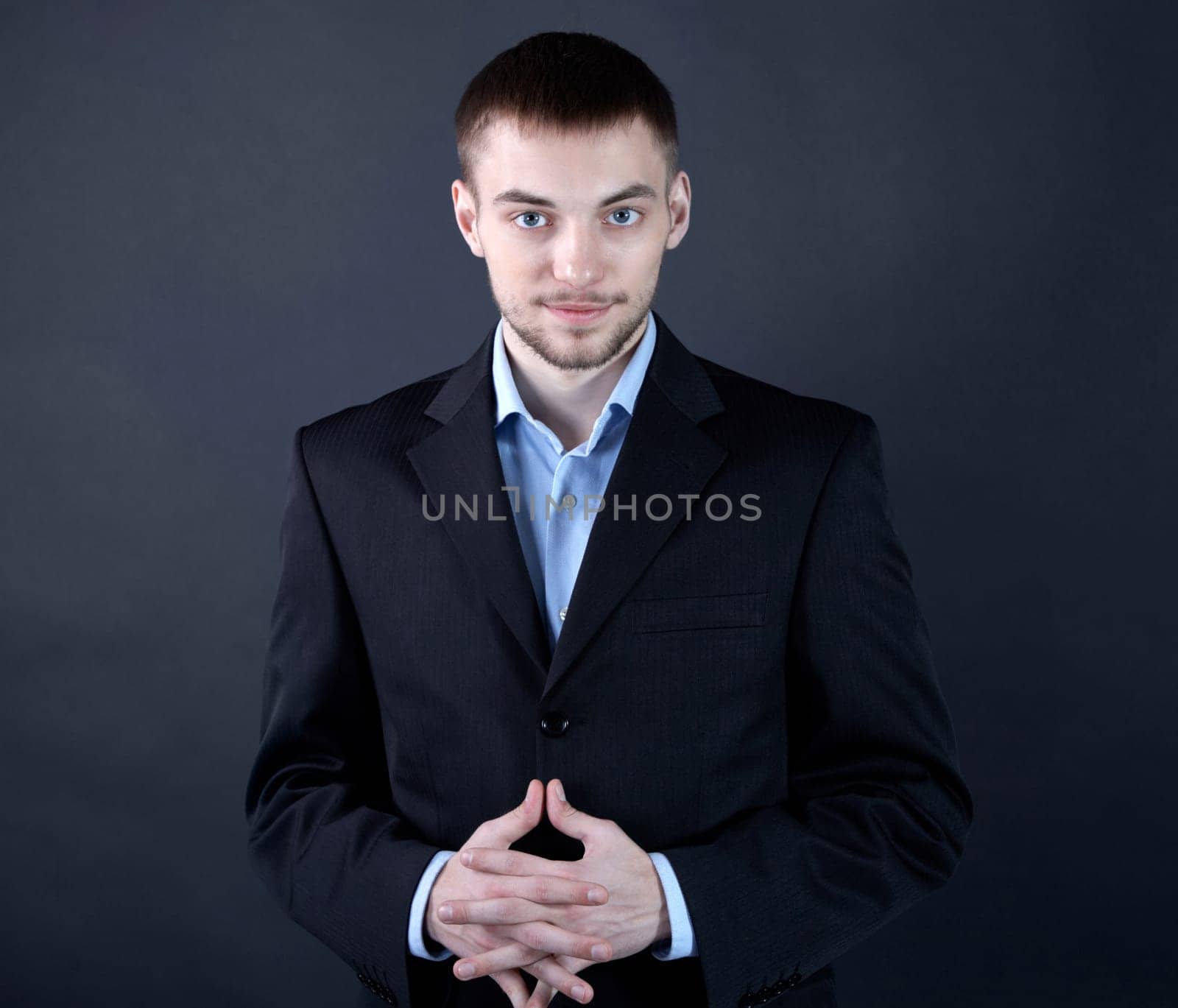 Portrait of stylish businessman looking at camera from darkness