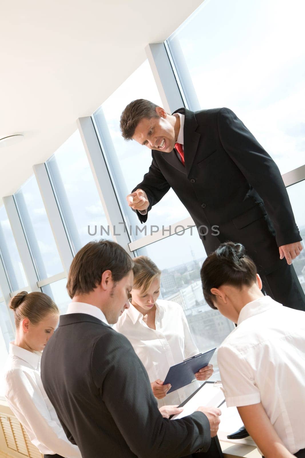 Angry ceo shouting at his employees surrounding him at meeting
