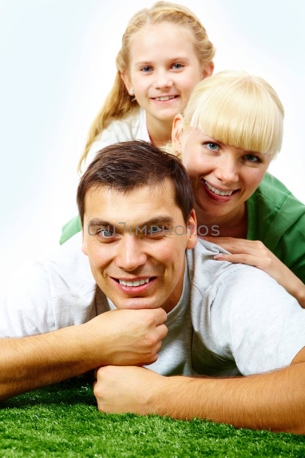 Portrait of happy family lying on grass and looking at camera