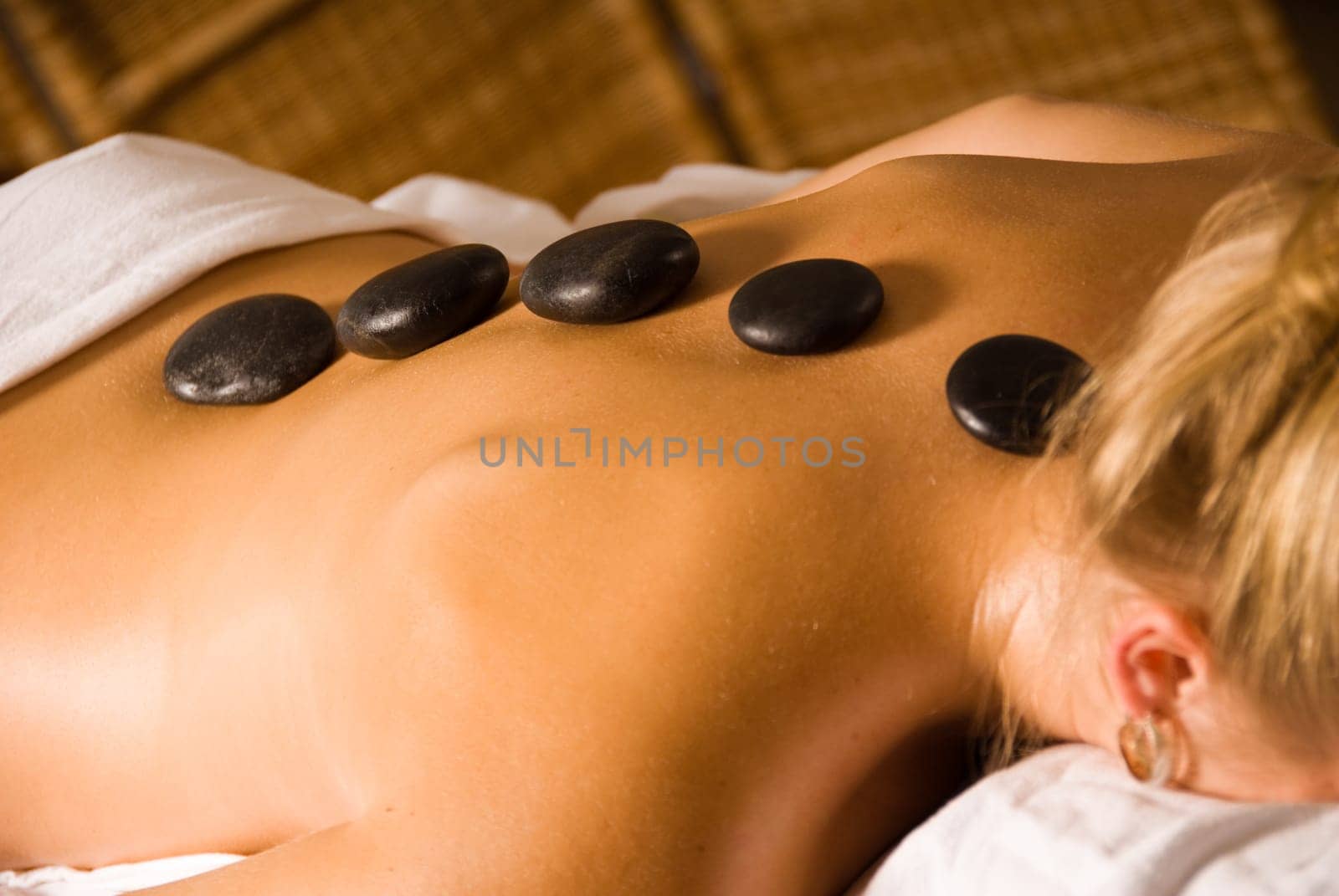 blond woman at a day spa with hot stones