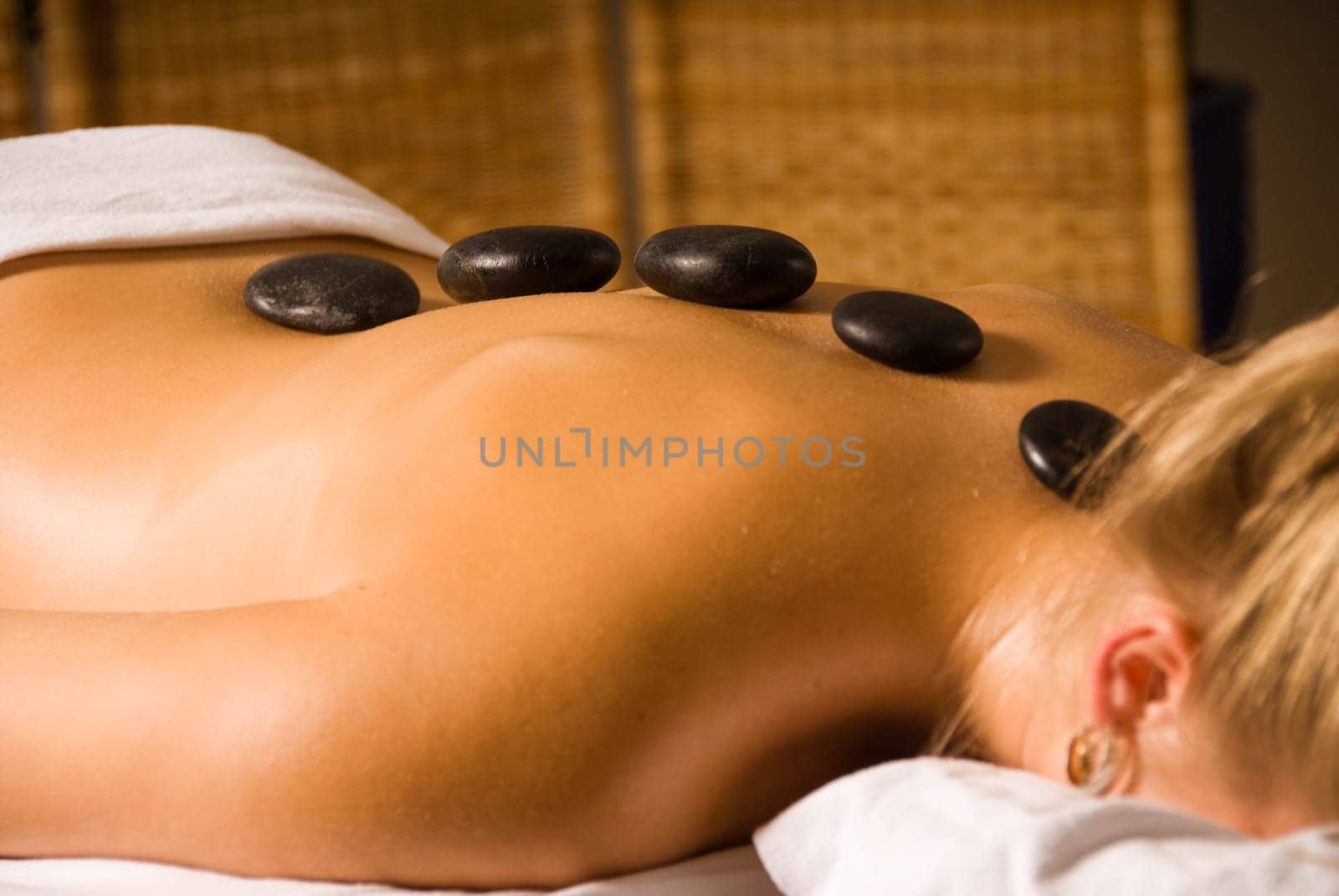 blond woman at a day spa with hot stones