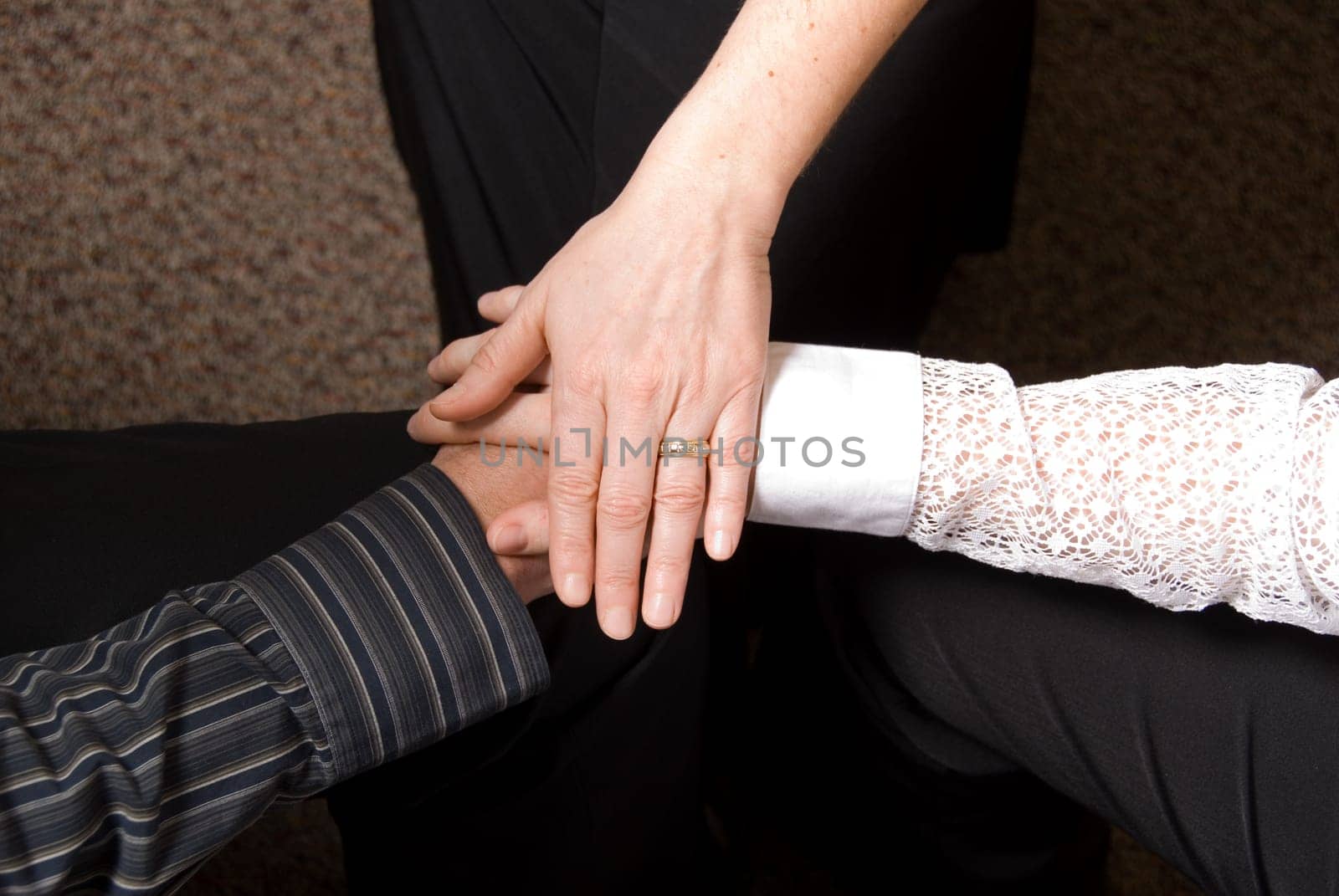 3 people clasping hands in a deal done