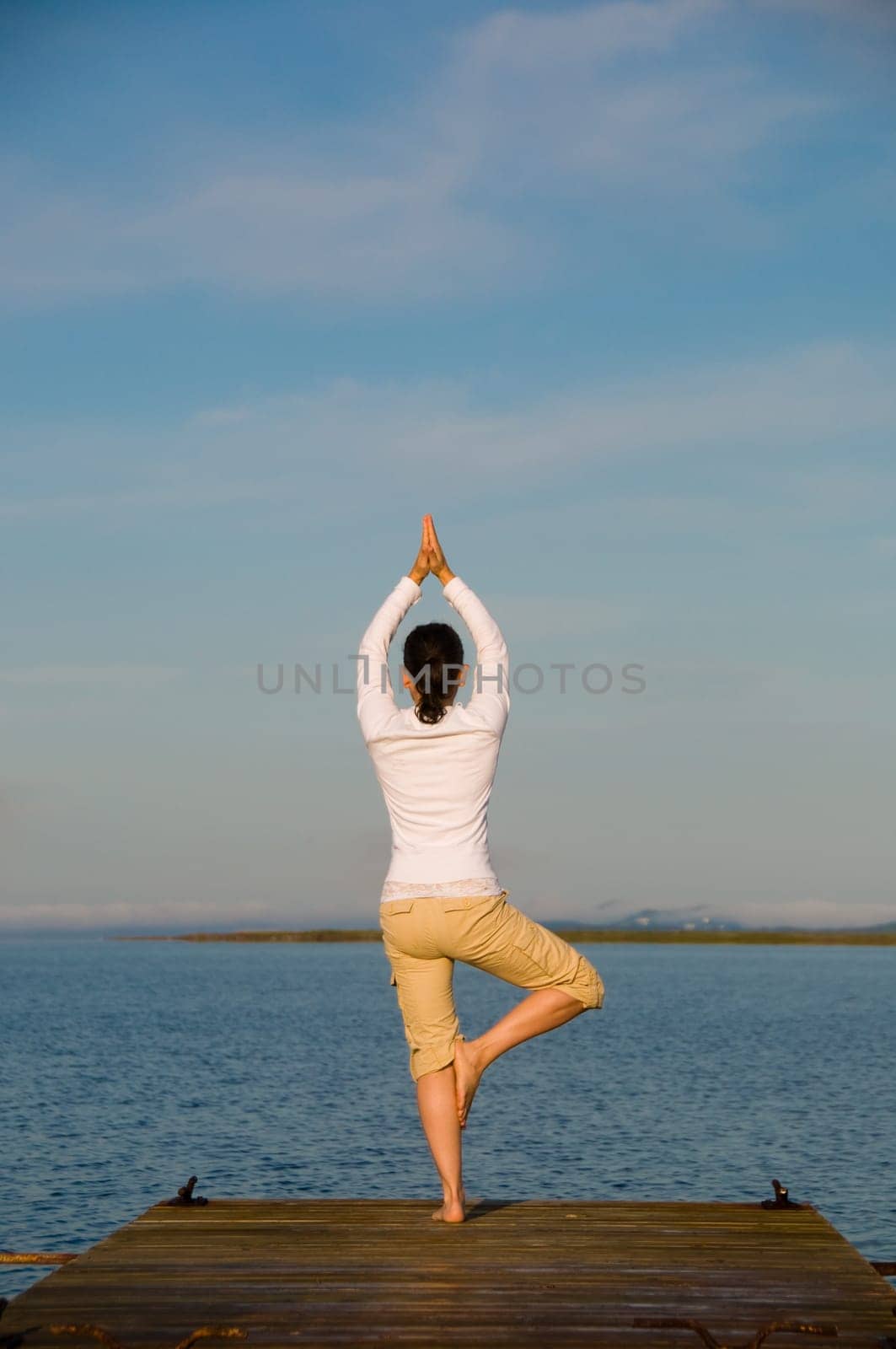Yoga Woman on a dock by the ocean