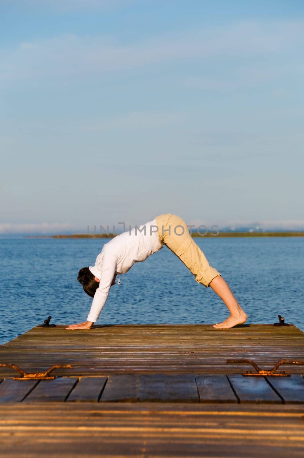 Yoga Woman on a dock by the ocean