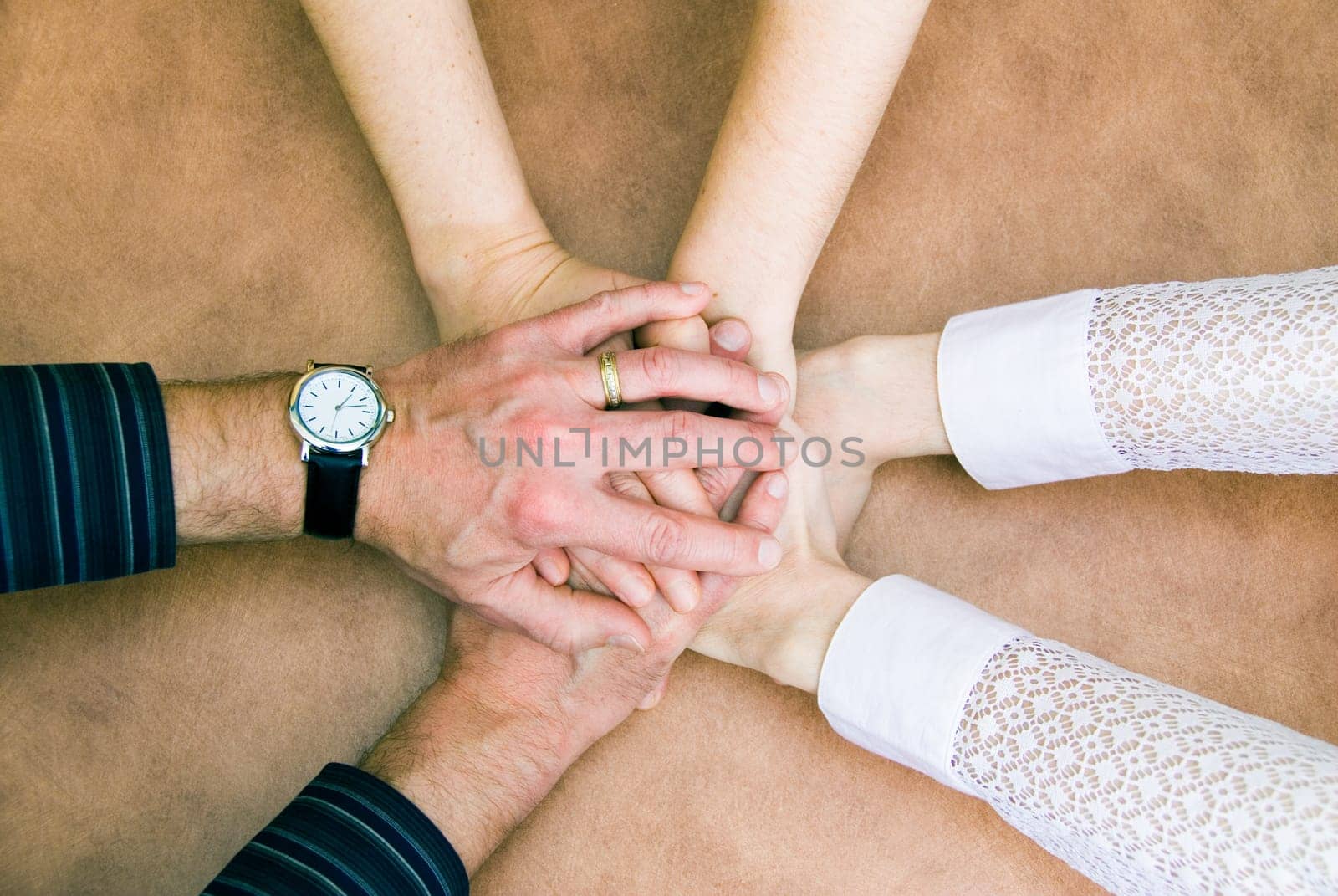 six hands clasp together in symbol of unity