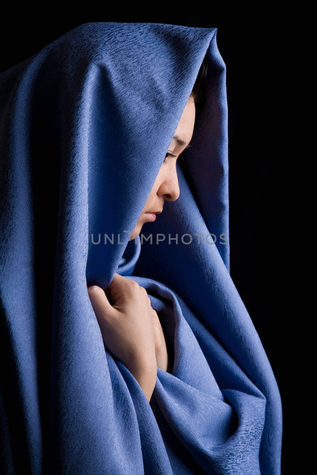 Portrait of pensive religious woman on a black background