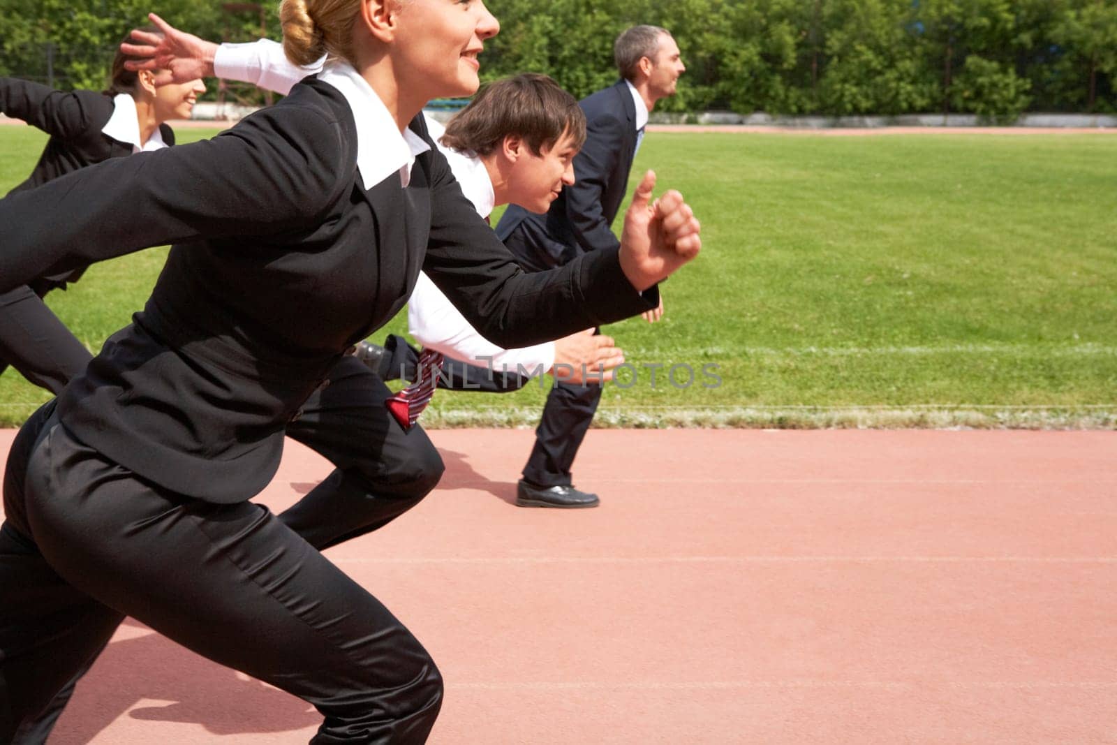 Image of active employees running down sport track