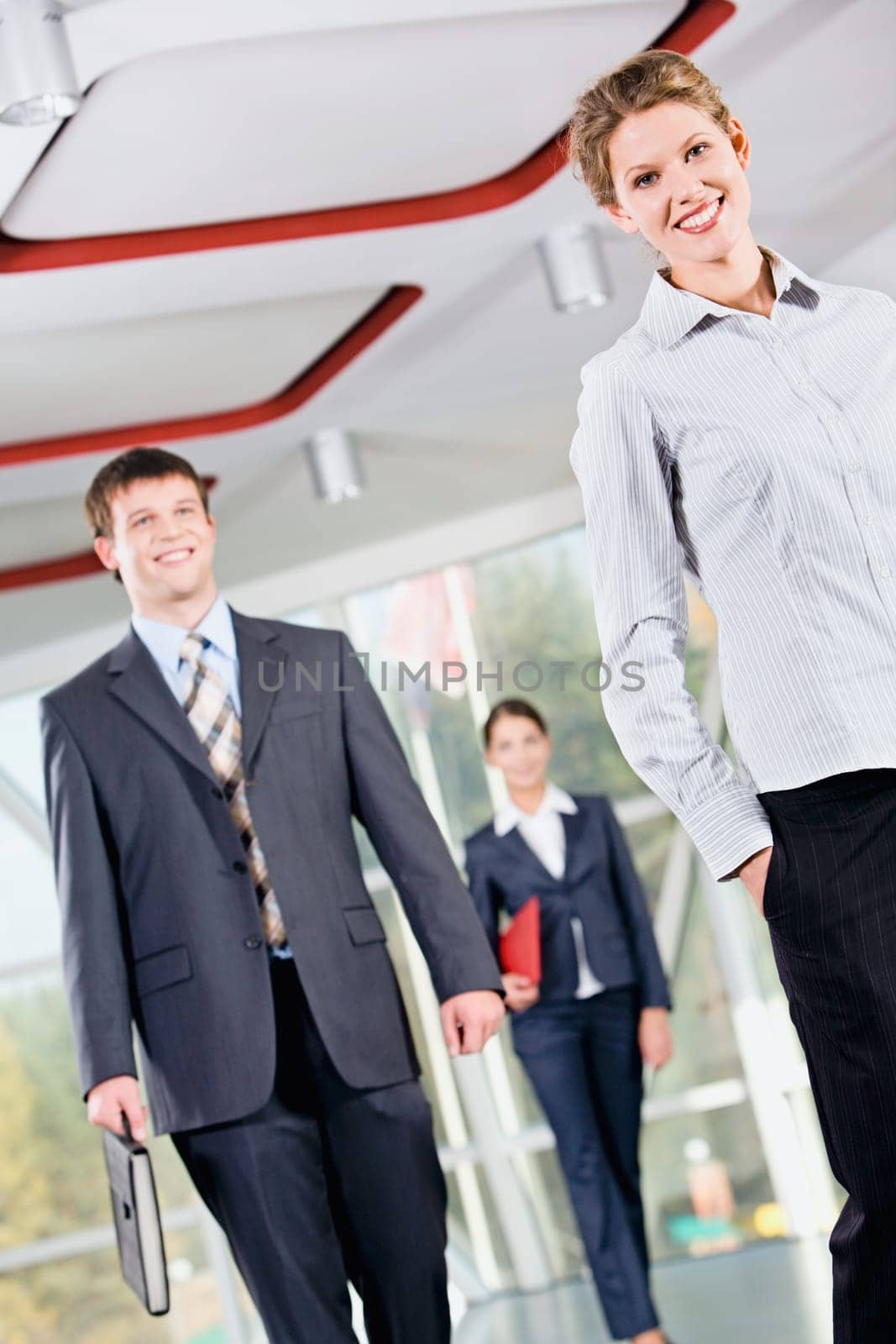 Confident woman is walking in front of business people