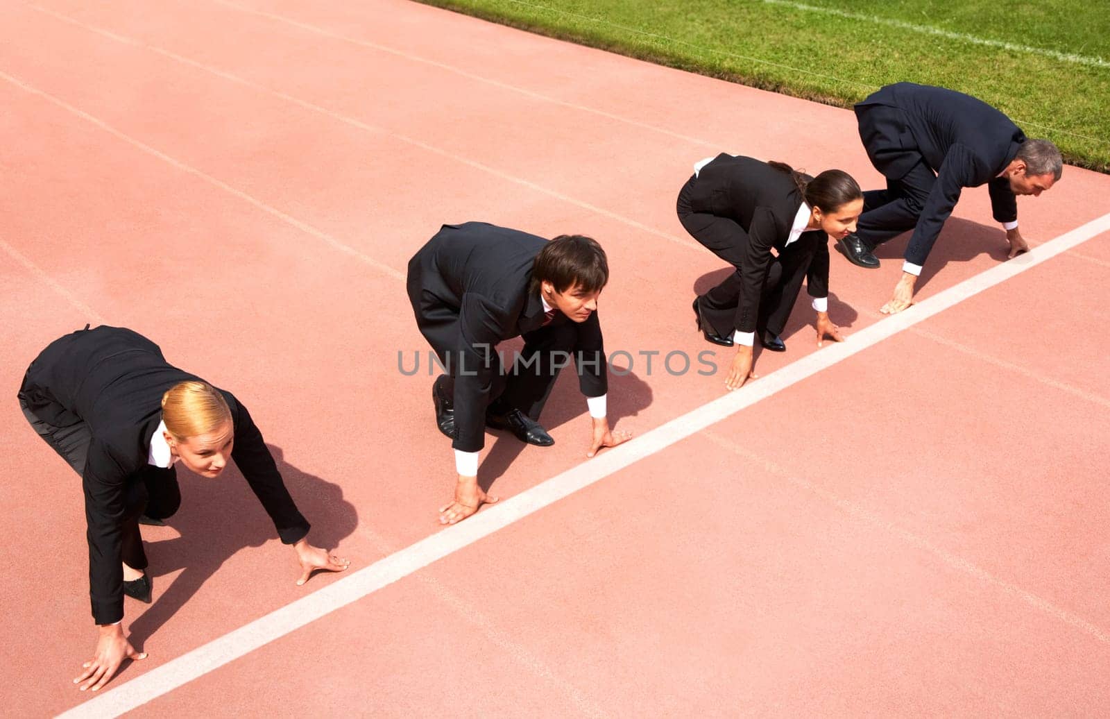 Confident business people lined up getting ready for race