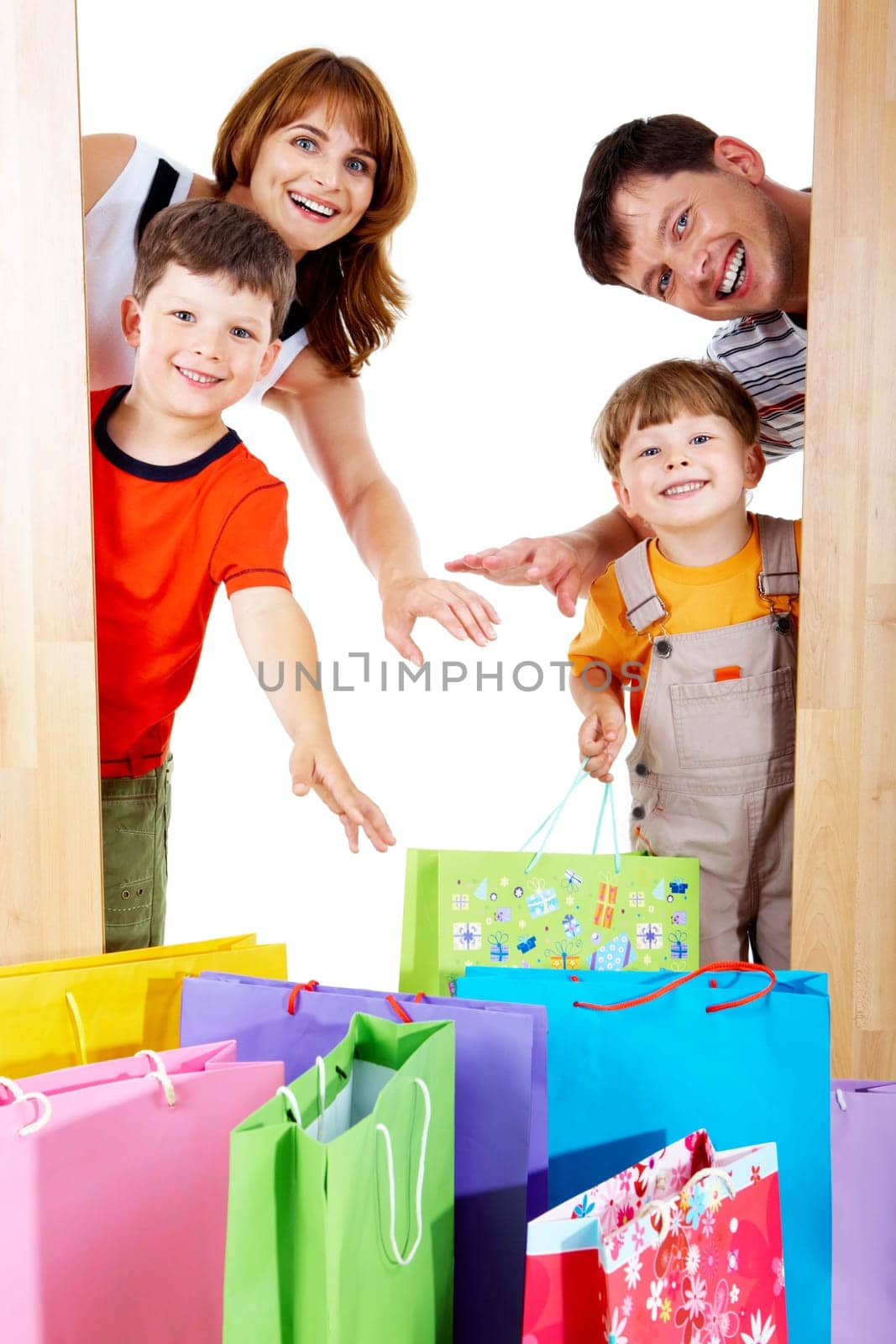 Image of cheerful family members near colorful shopping bags looking with happy expression