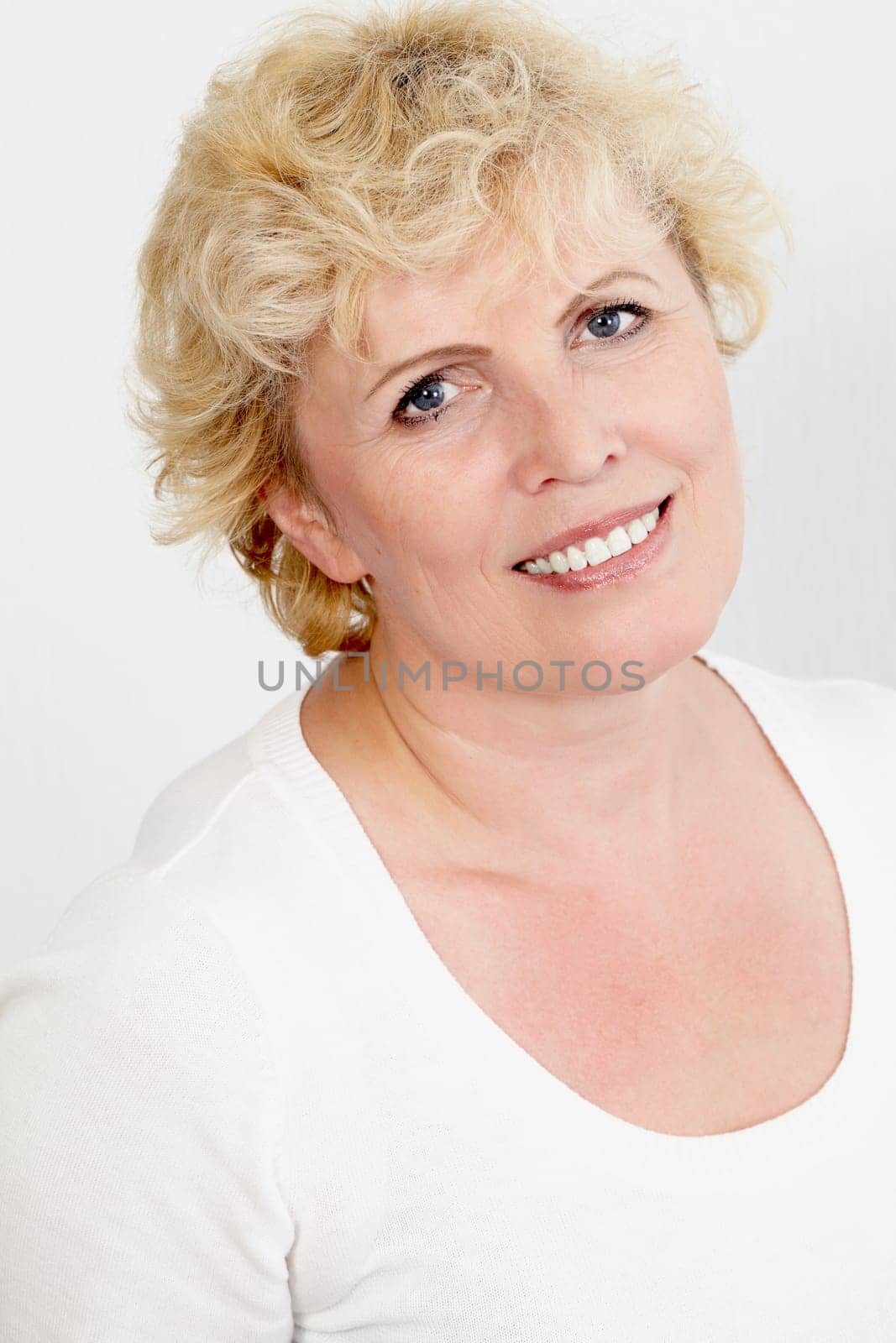 Portrait of happy aged woman looking at camera with smile