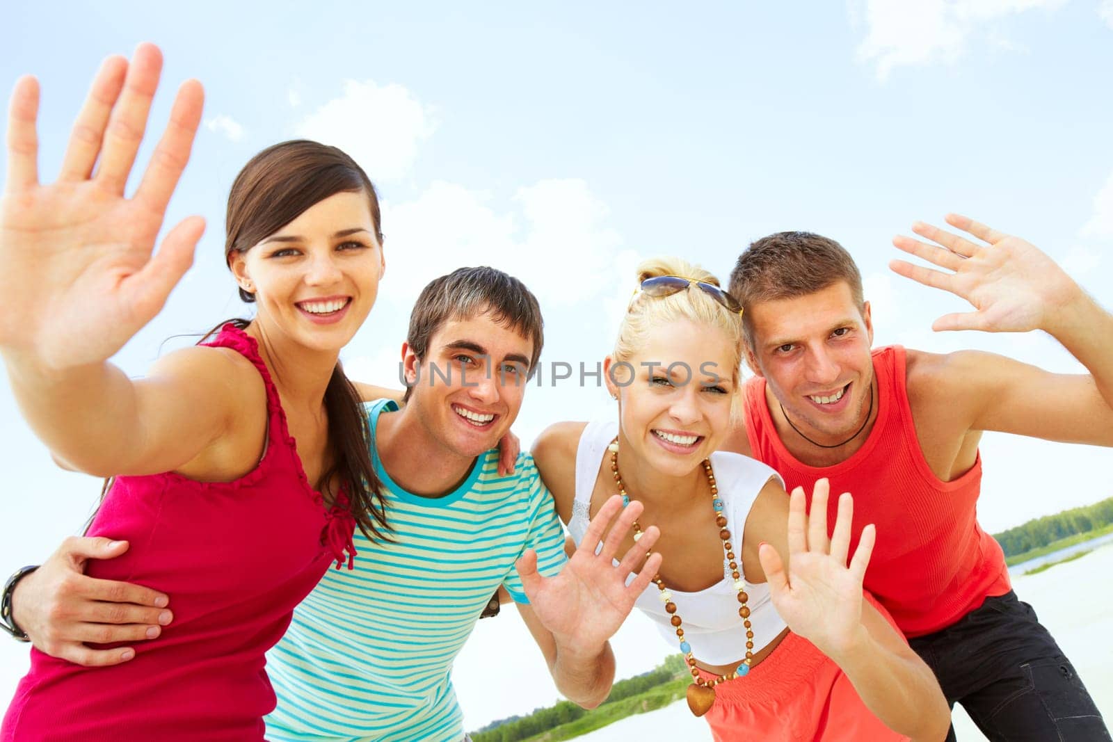 Two happy couples looking at camera and waving